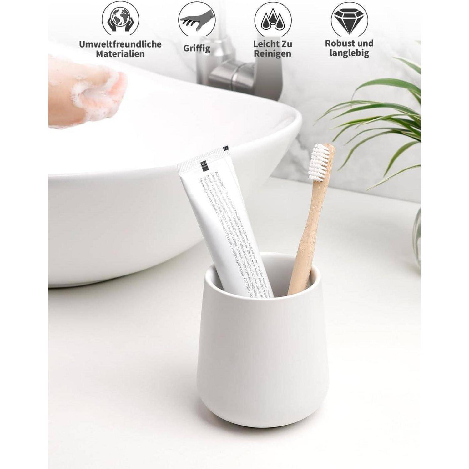 Eine weiße Tasse enthält eine Bambuszahnbürste und Zahnpasta neben einem Waschbecken; Deutsche Etiketten besagen umweltfreundliche Materialien, rutschfest, leicht zu reinigen, langlebig.