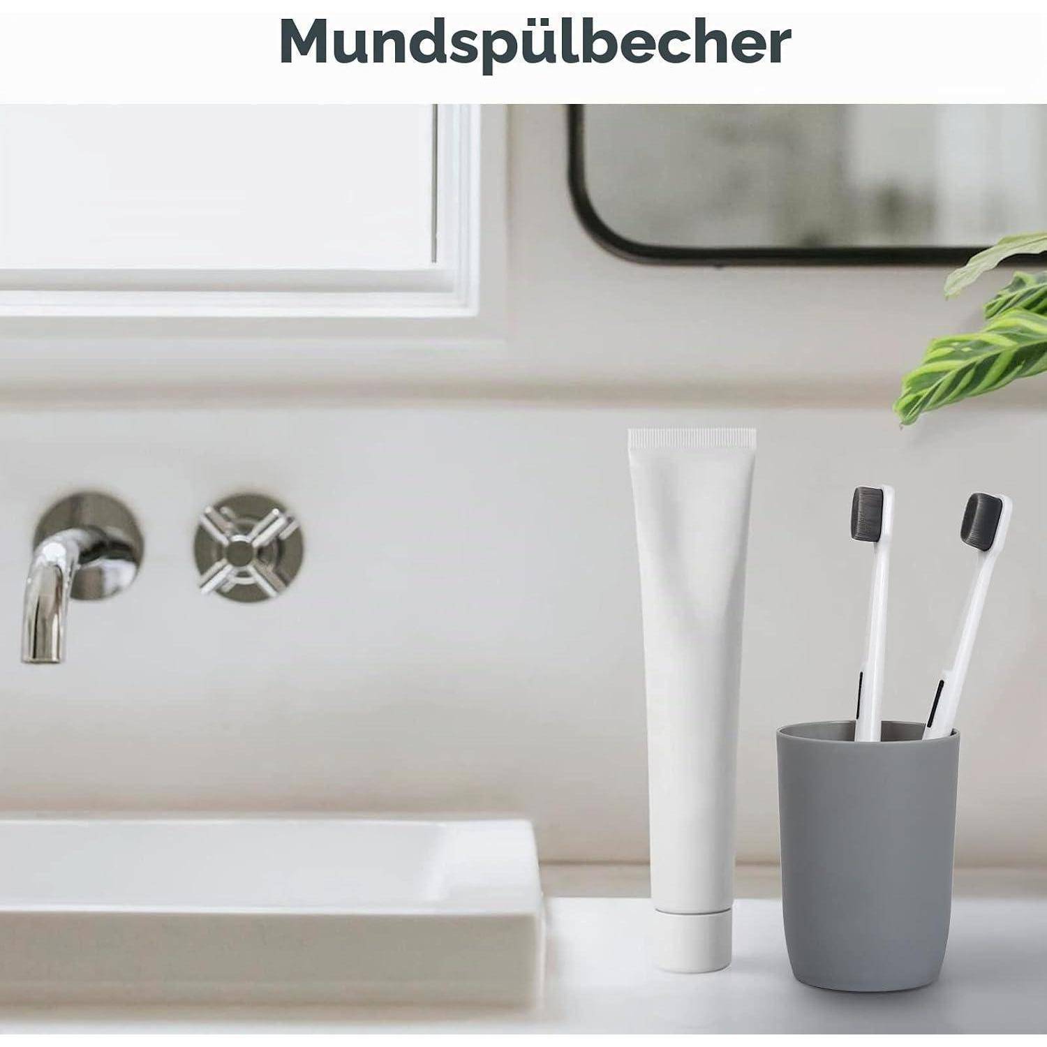 Badezimmer-Spülenbereich mit einer weißen Mundspültube und zwei Zahnbürsten in einem grauen Becher, oben mit 