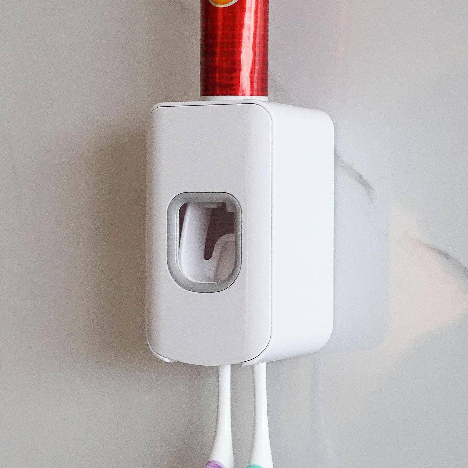 Weißer wandmontierter automatischer Handdesinfektionsspender mit sichtbarer roter Nachfüllflasche oben und zwei unteren Düsen