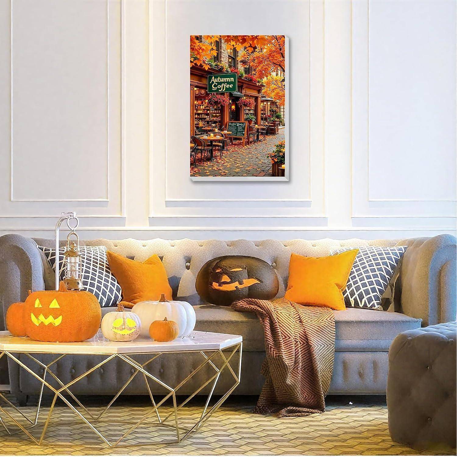 Gemütliches Wohnzimmer, das für Halloween dekoriert ist, mit Kürbissen auf dem Couchtisch, orangefarbenen Kissen, einer Decke und einem Herbstcafé-Wandkunstdruck.