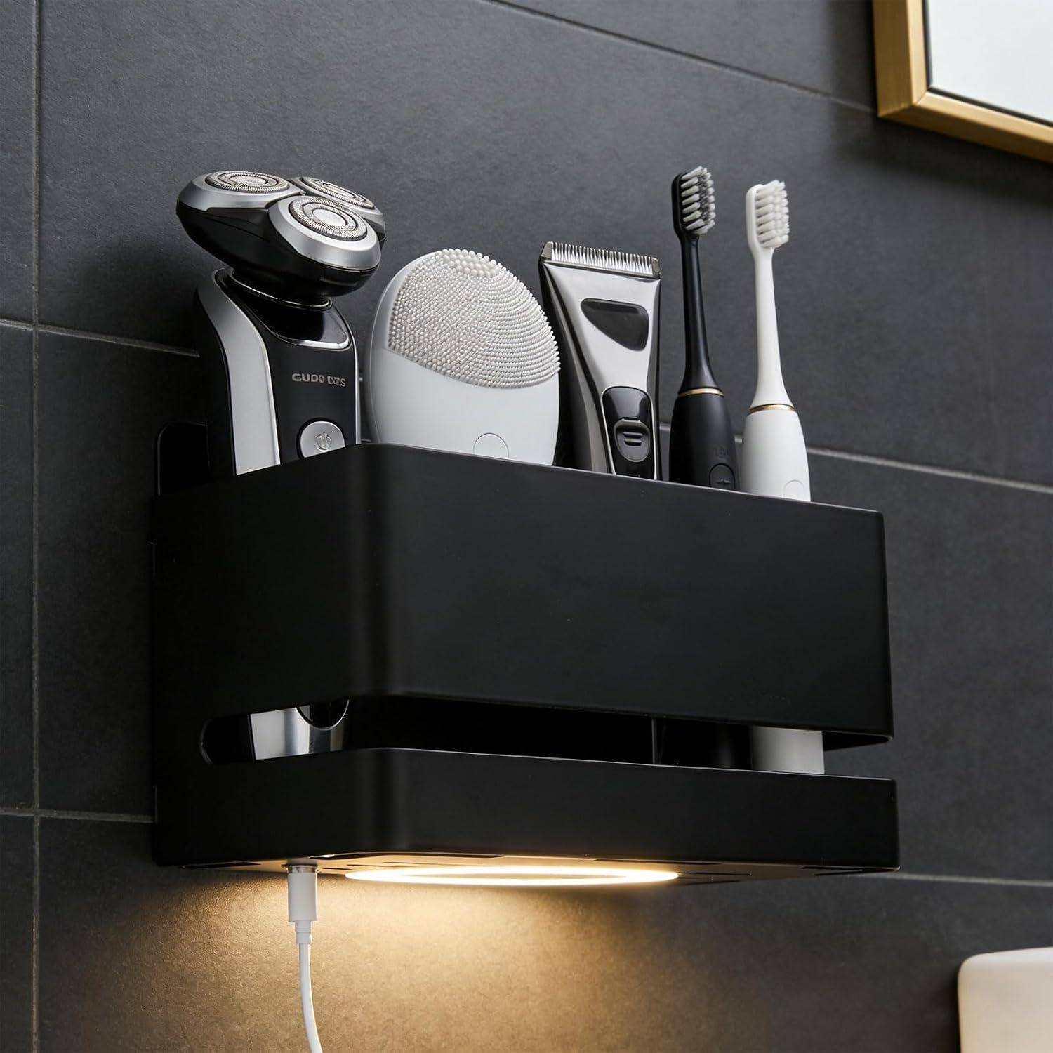 An der Wand montierter Badezimmerorganizer mit Elektrorasierer, Gesichtsbürste, Trimmer und zwei Zahnbürsten, mit Licht darunter und Ladekabel.