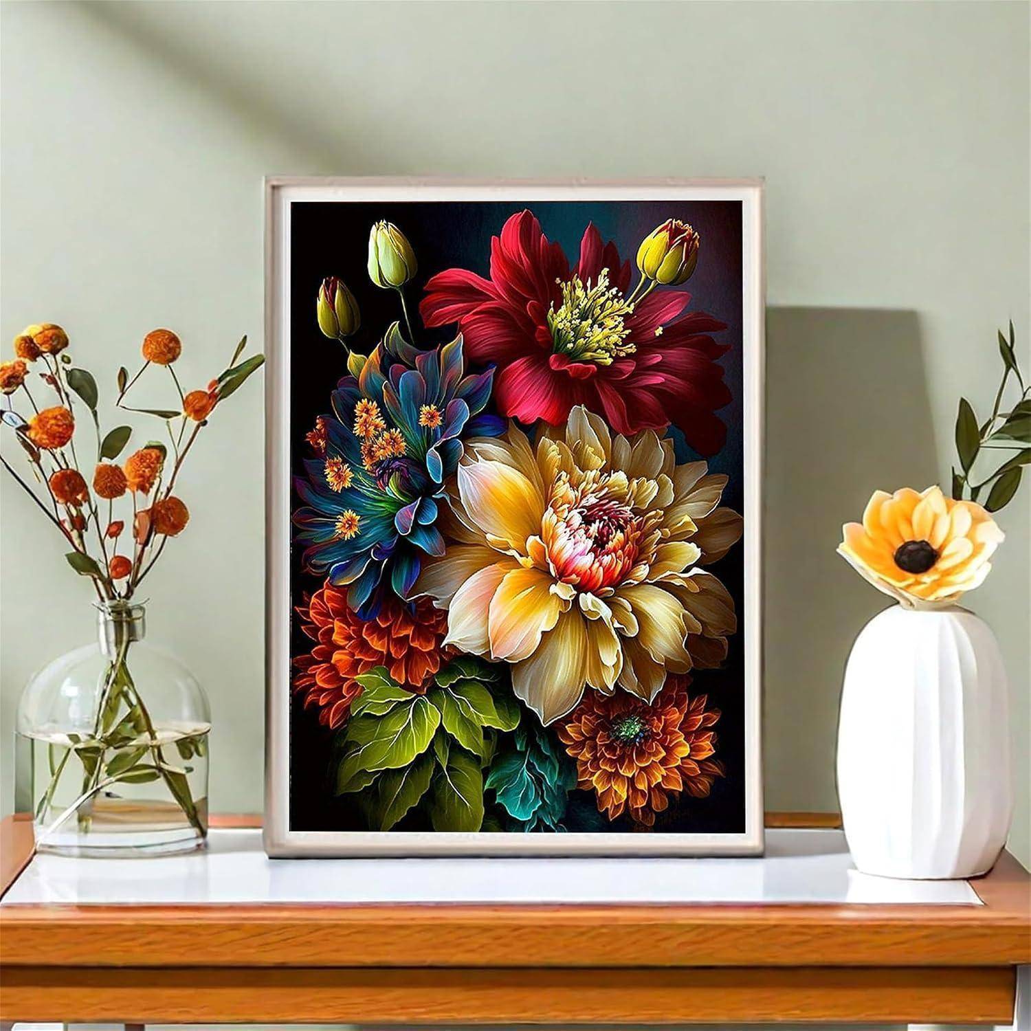 Gerahmtes buntes Blumenkunstwerk auf einem Kaminsims, flankiert von einer Vase mit orangefarbenen Blumen und einer weißen Vase mit einer gelben Blüte.