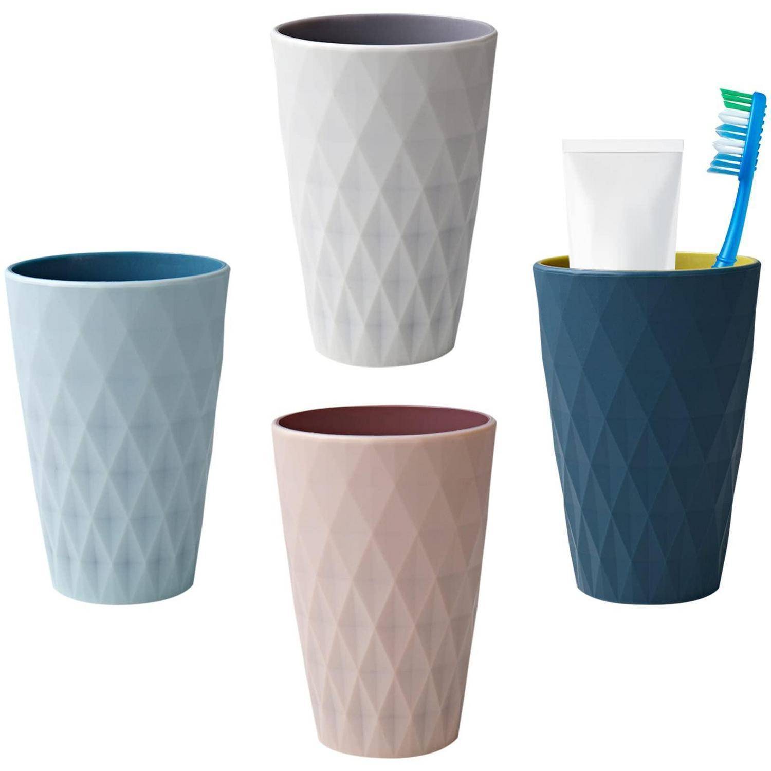 Vier strukturierte Kunststoffbecher in Pastellfarben; ein dunkelblauer Becher enthält eine Zahnbürste und einen weißen Becher.