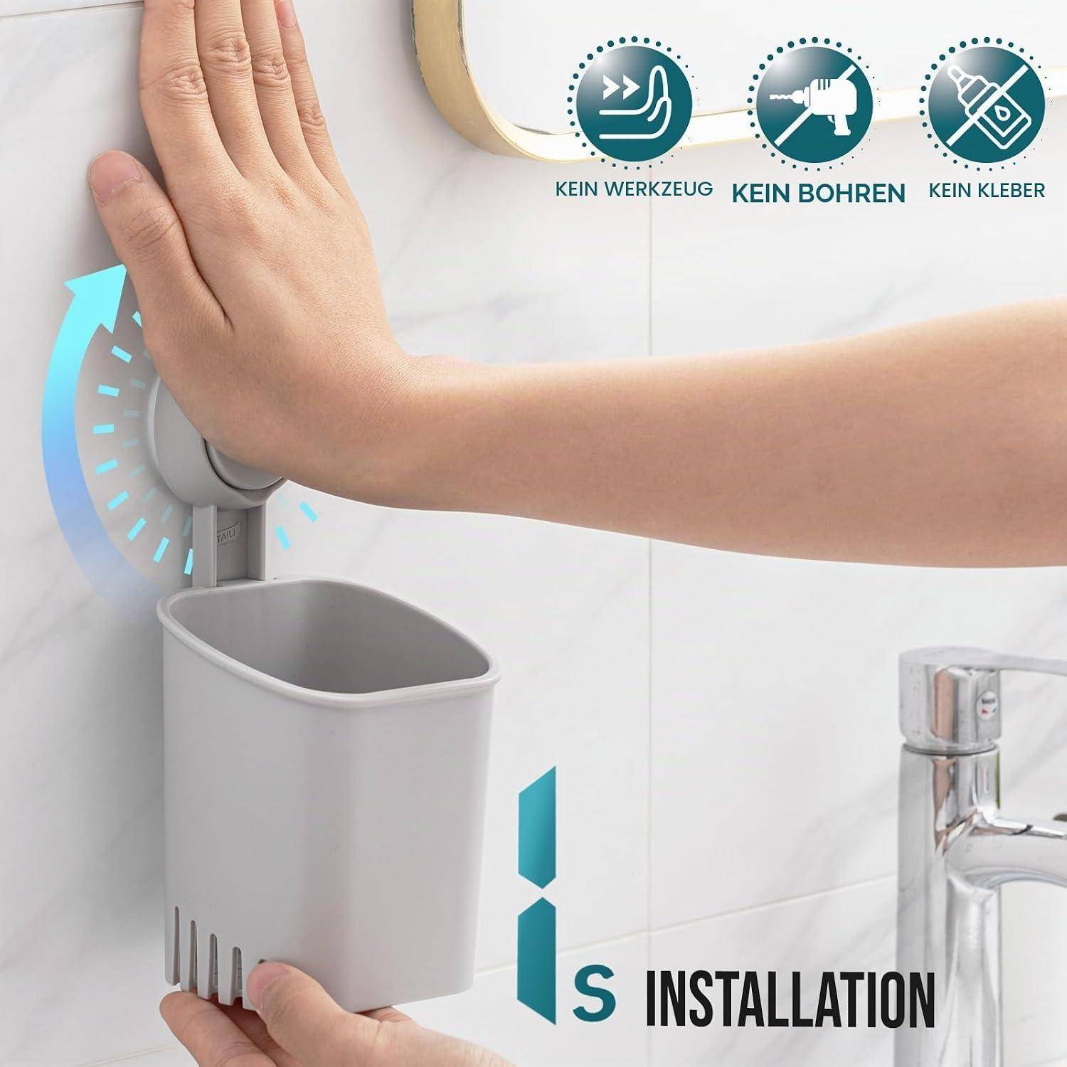 Hand drückt einen an der Wand angebrachten grauen Badezimmer-Aufbewahrungsbecher mit Saugnapf; Symbole sagen „KEIN WERKZEUG