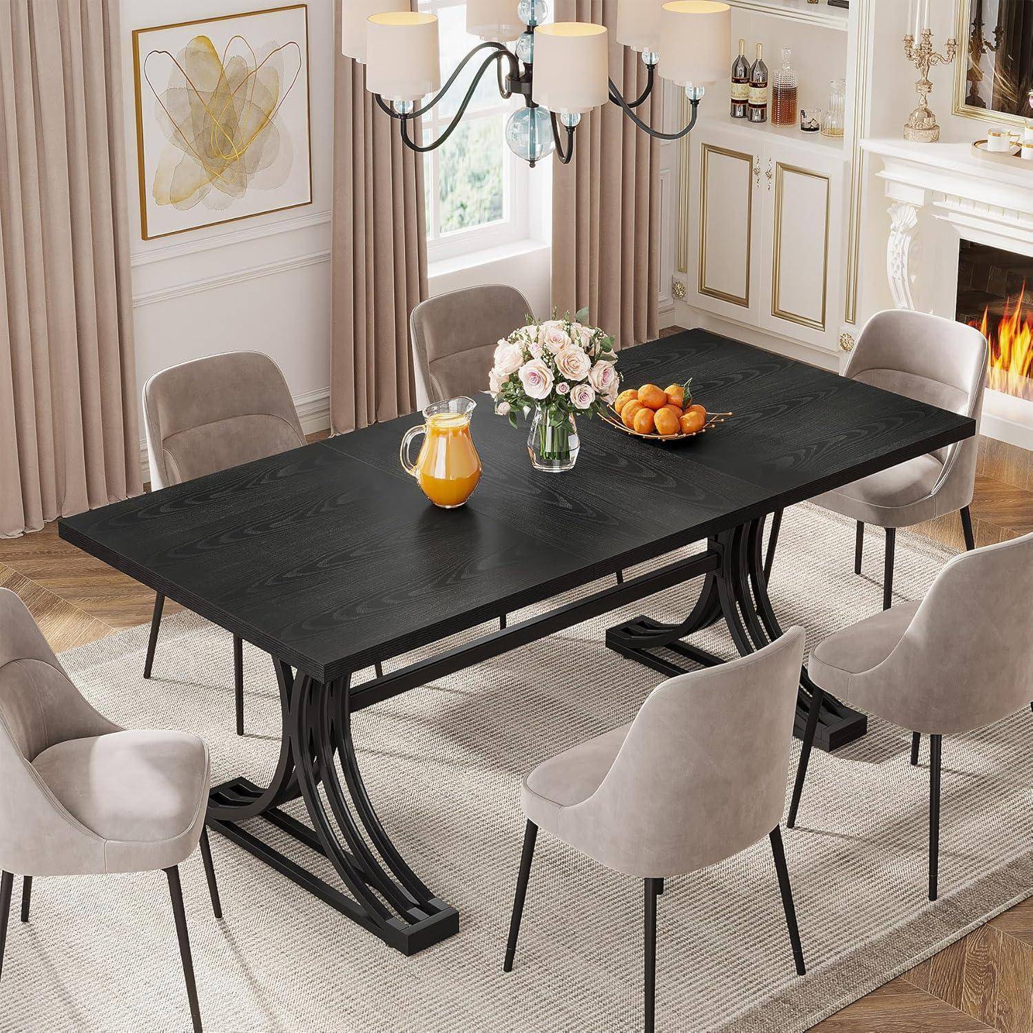 Modernes Esszimmer mit einem schwarzen rechteckigen Tisch, sechs beigen Stühlen, einer Blumenvase, einem Saftkrug und einer Schale mit Orangen neben einem brennenden Kamin.