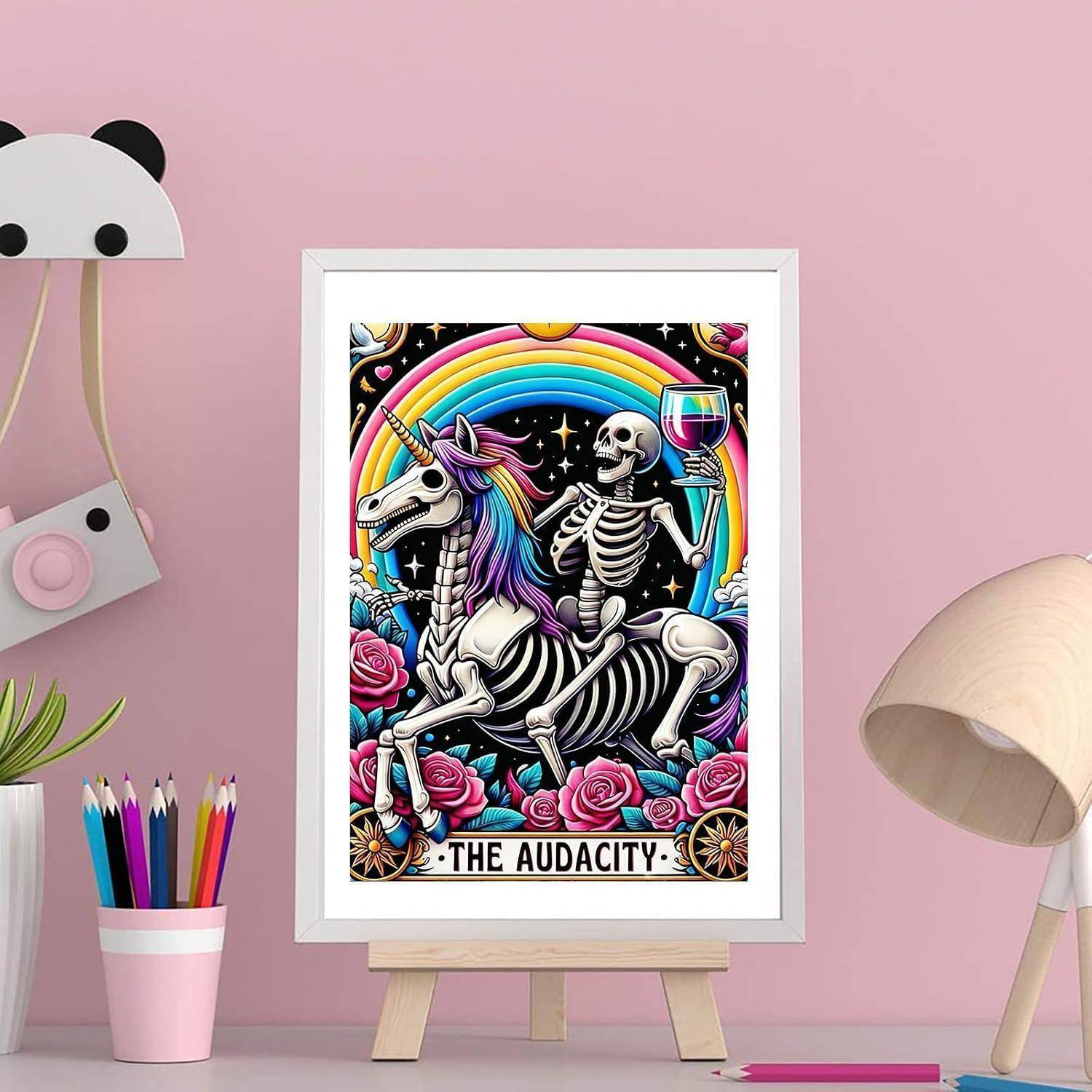 Gerahmtes Poster eines Skeletts, das auf einem Einhorn unter einem Regenbogen reitet, ein Weinglas hält, mit der Aufschrift „DIE UNVERSCHÄMTHEIT.