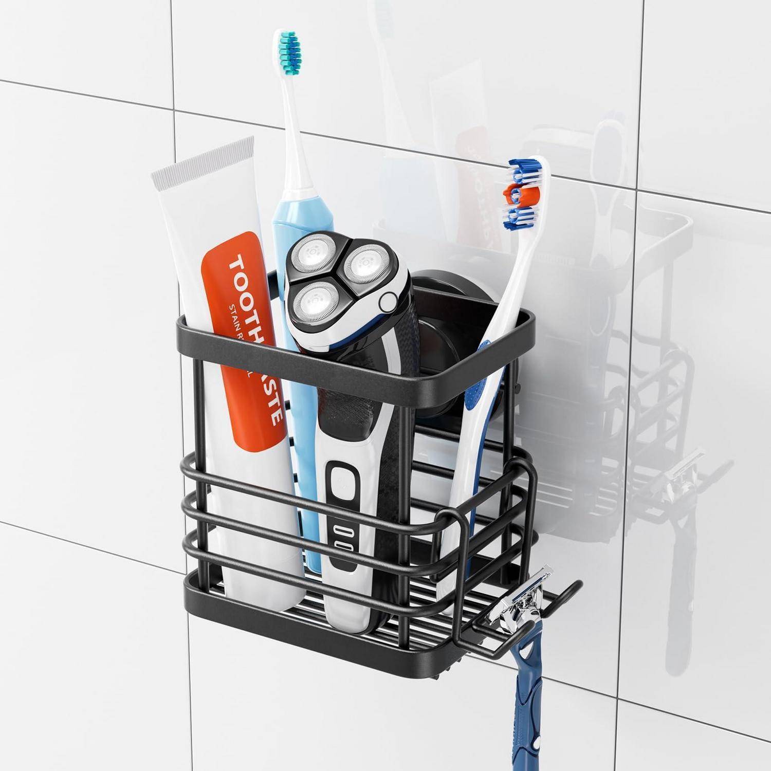 An der Wand montierter schwarzer Badezimmer-Caddy mit Zahnpasta, elektrischem Rasierer und zwei Zahnbürsten auf weißer gekachelter Wand.