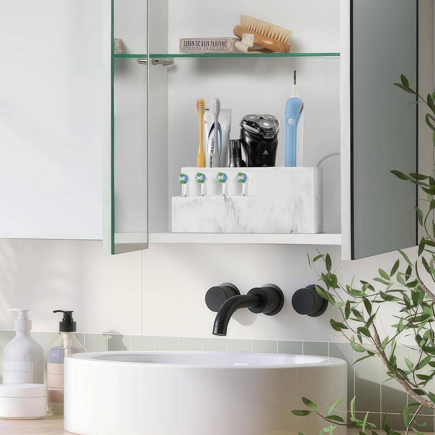 Badezimmereitelkeit mit einem runden weißen Waschbecken, schwarzem Wandarmatur, offener Spiegelschrank mit Zahnbürsten und einem Rasierer sowie Toilettenartikeln auf der Arbeitsplatte.