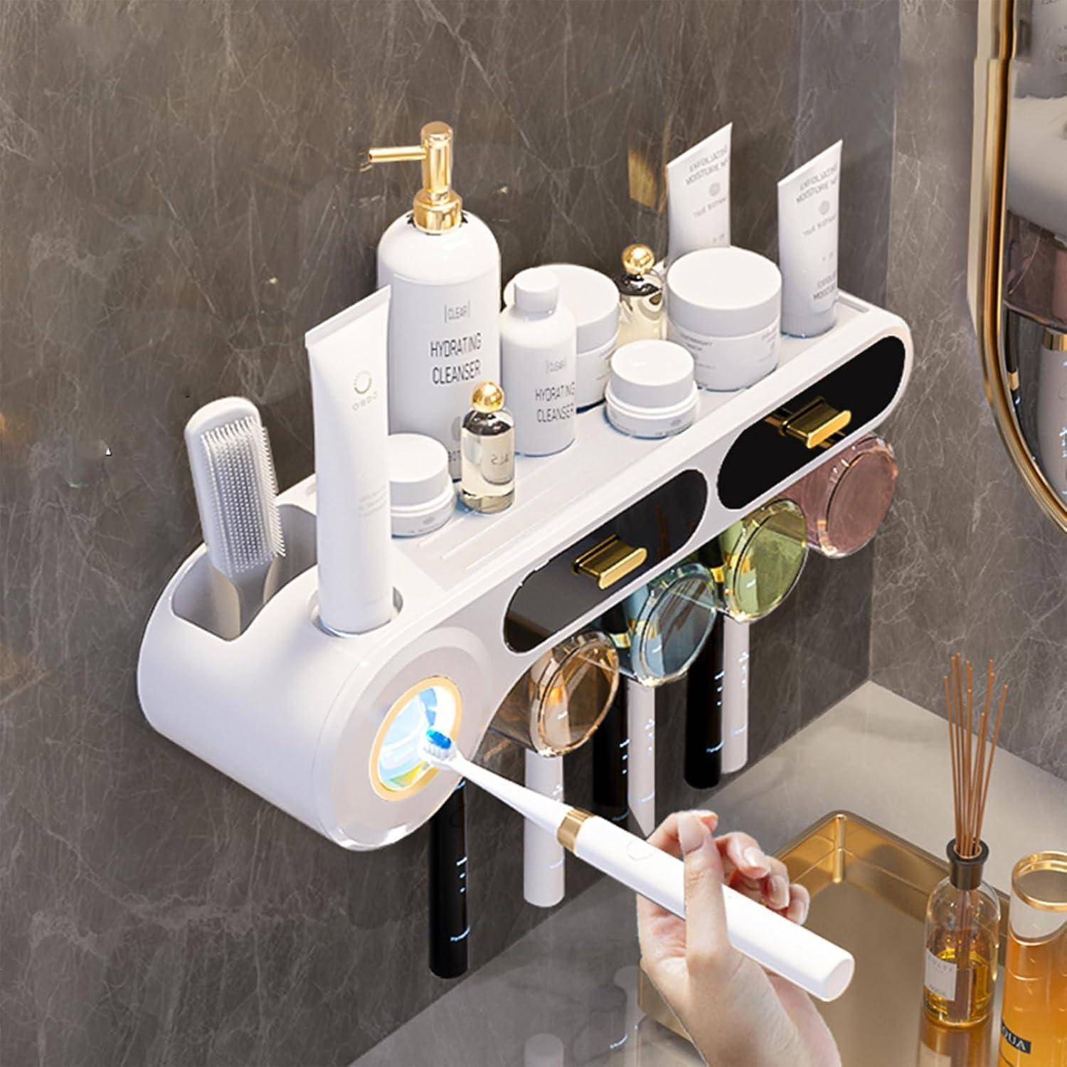 Wandmontierter Badorganizer mit Toilettenartikeln, Zahnbürsten und Bechern; eine Hand benutzt eine elektrische Zahnbürste unter einem integrierten Licht.