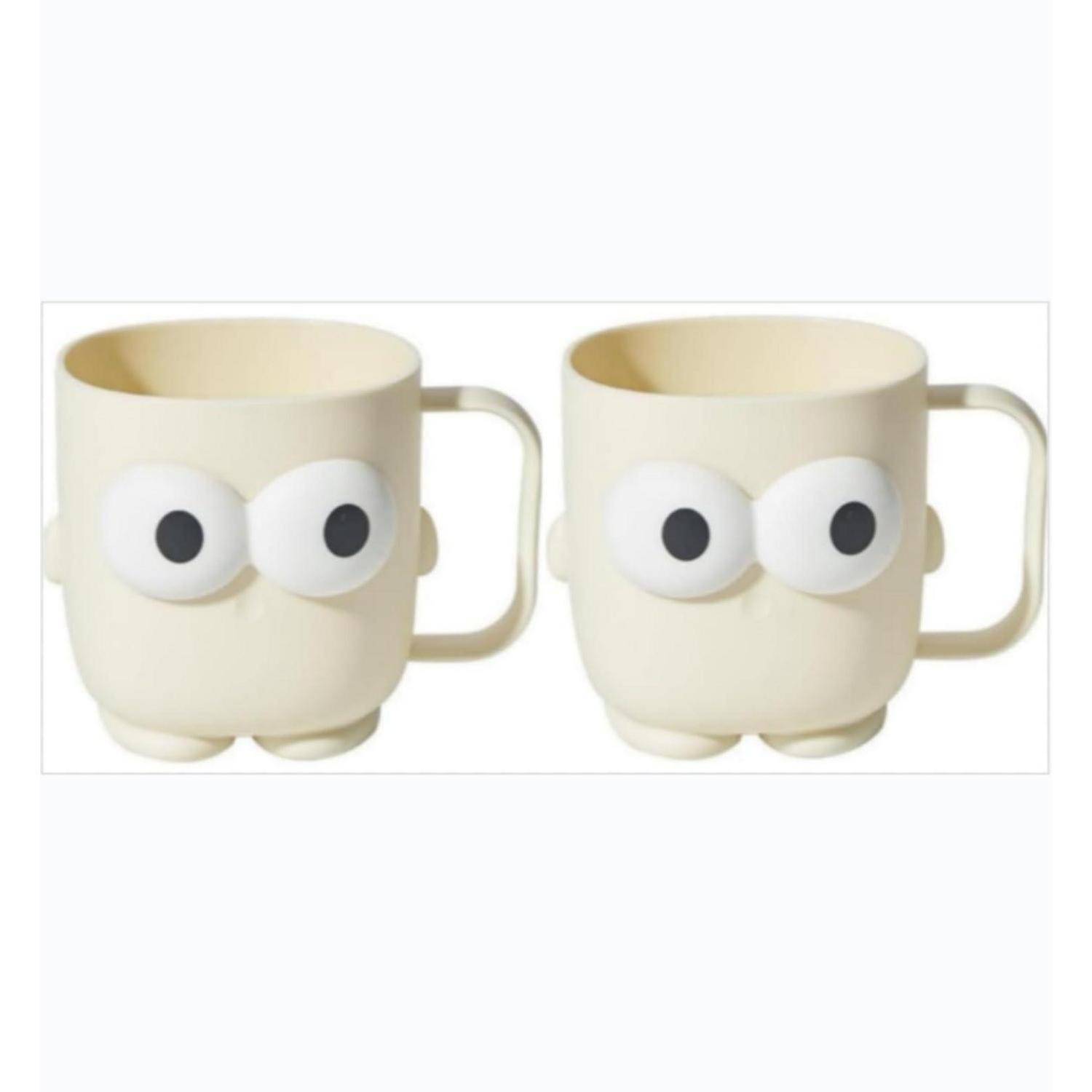 Zwei cremefarbene Tassen mit Cartoon-Augen und Füßen werden nebeneinander auf weißem Hintergrund gezeigt.