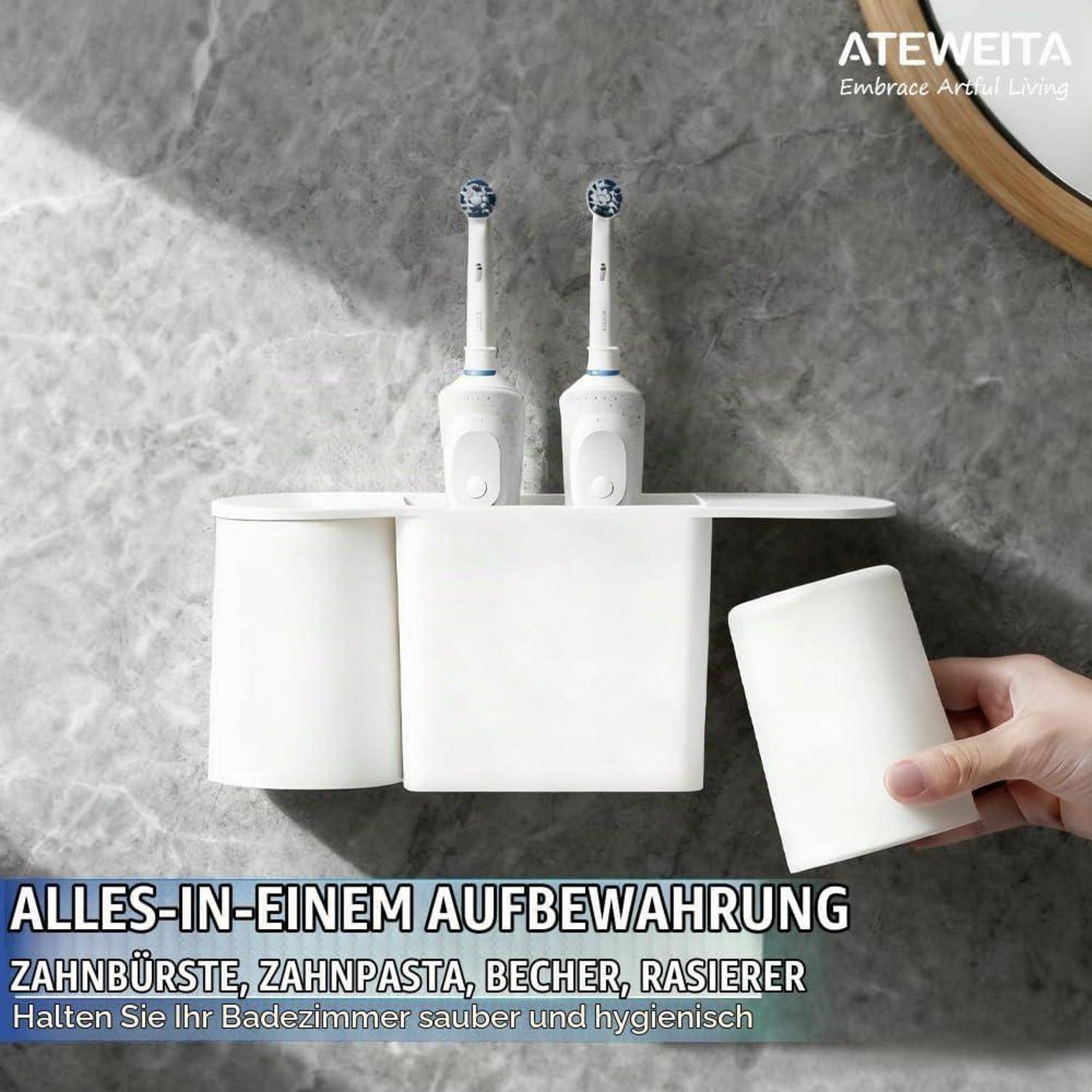 An der Wand montierter weißer Badezimmerorganizer mit zwei elektrischen Zahnbürsten, Zahnpasta und Bechern, wobei eine Hand einen Becher herausnimmt.