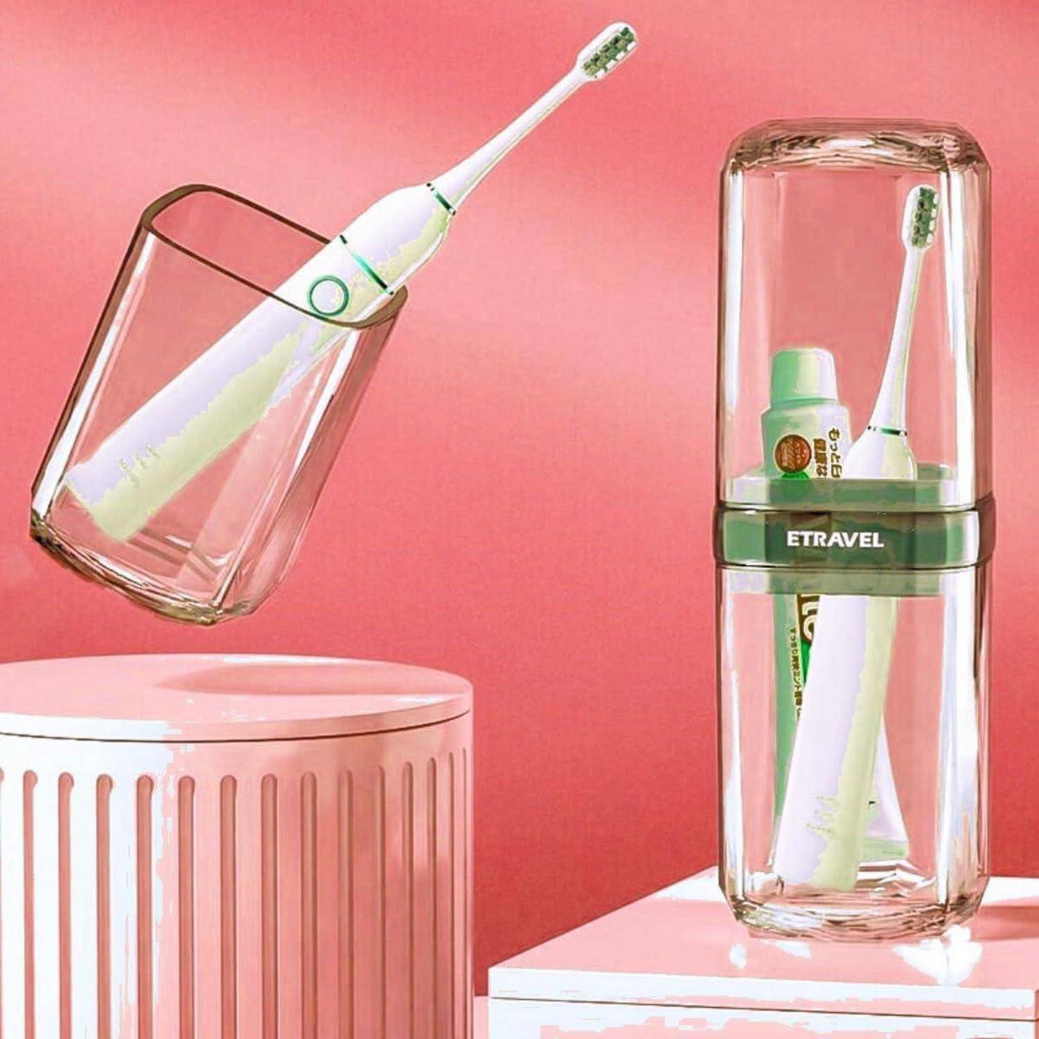 Elektrische Zahnbürste und Zahnpasta in transparenten Reiseetuis auf rosa Oberflächen vor rosa Hintergrund.