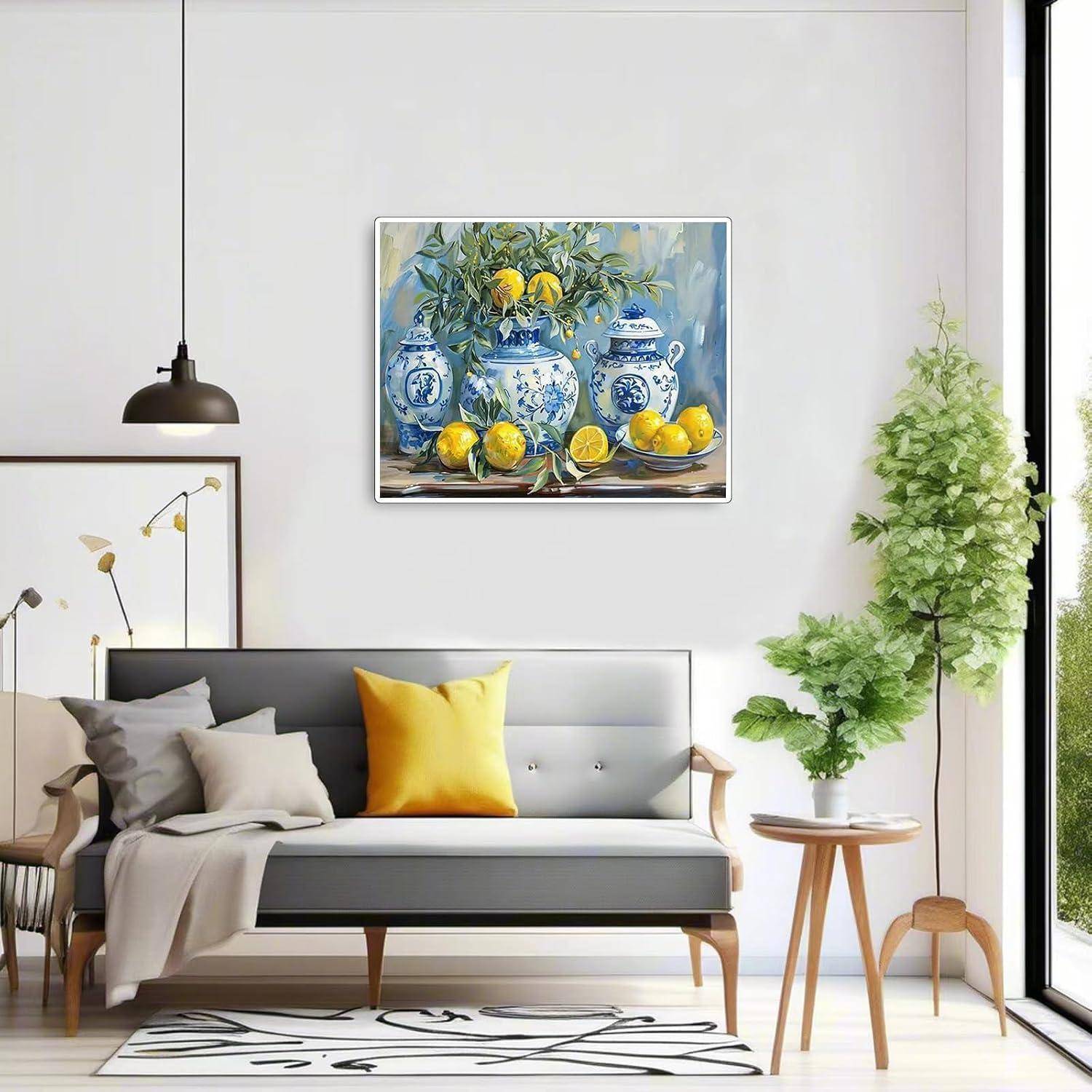 Modernes Wohnzimmer mit einem grauen Sofa, gelbem Zierkissen, Topfpflanzen und einem gerahmten Stillleben mit blauen Vasen und Zitronen über der Couch.