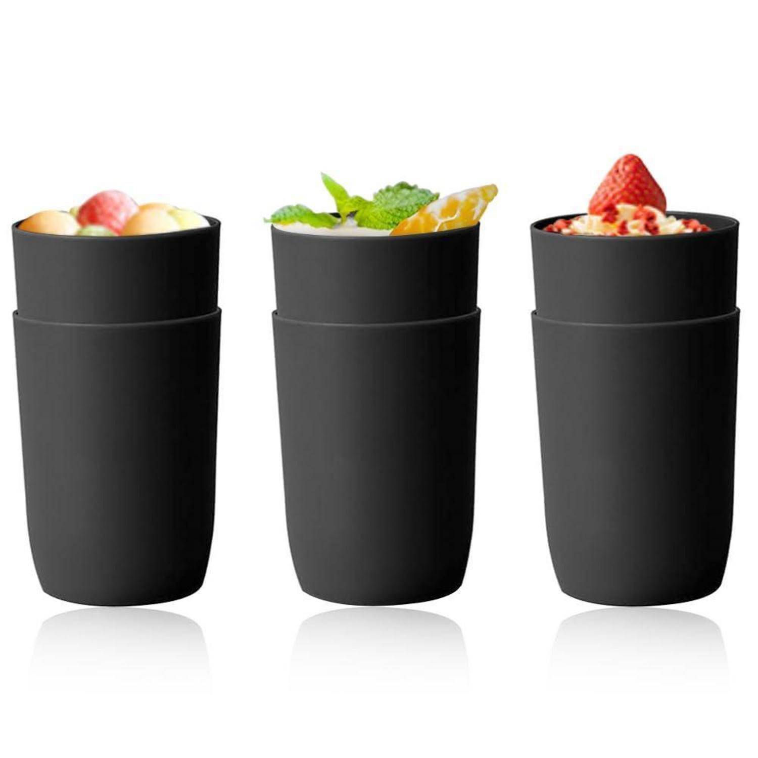 Drei schwarze isolierte Tassen oder Becher mit Fruchtdesserts oder Getränken auf weißem Hintergrund gefüllt.