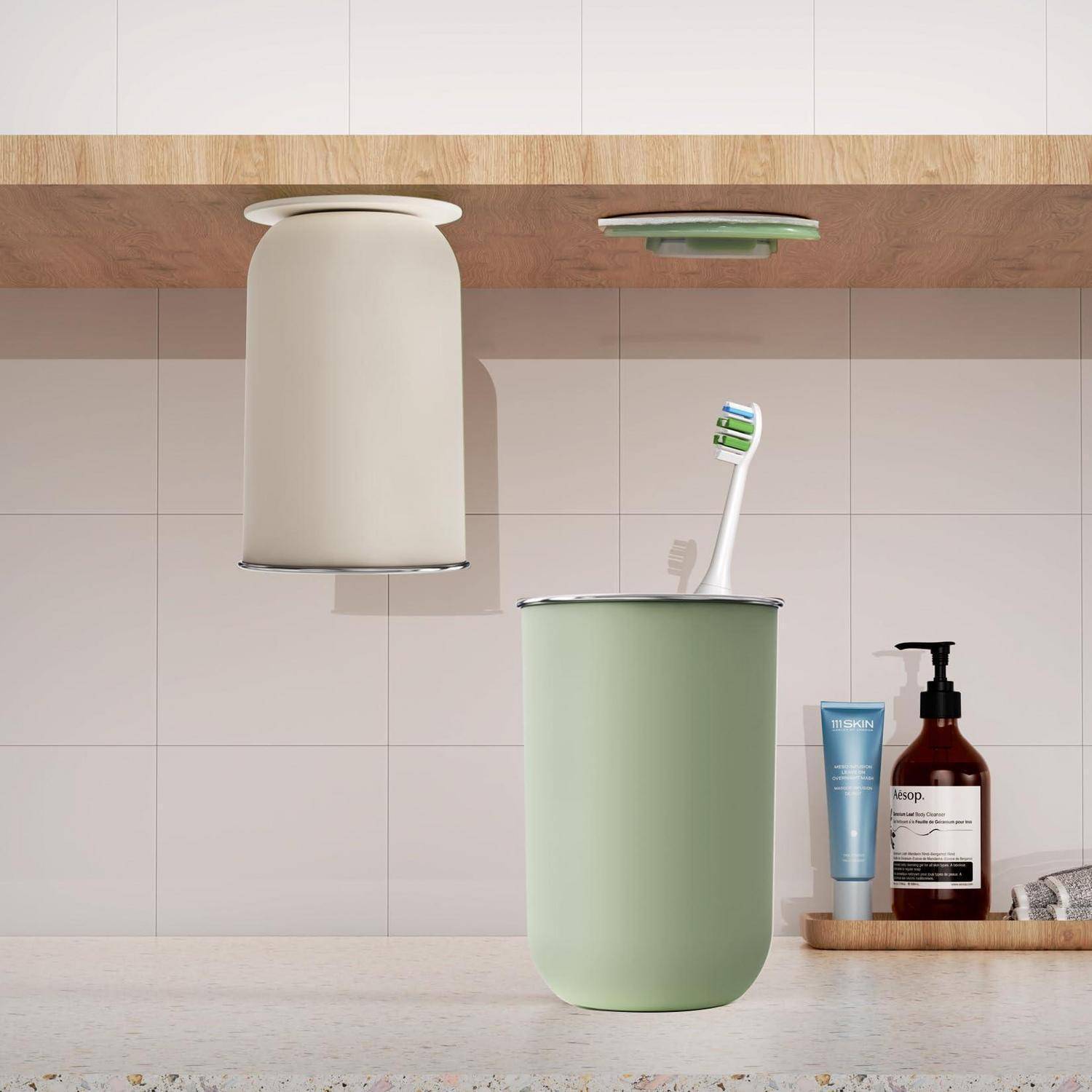 Zahnbürste in einem blassgrünen Becher auf einer Badezimmerablagefläche unter einem Spiegelschrank, mit Seifen- und Lotionsflaschen im Hintergrund.