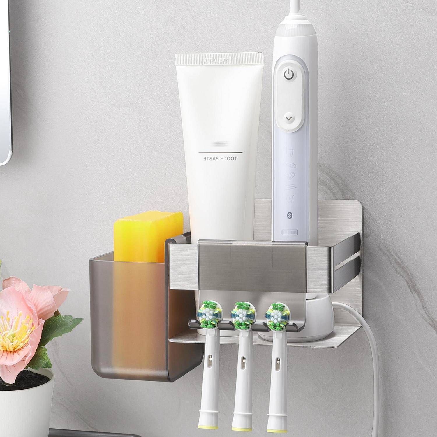 Badezimmer-Wandorganizer mit einer elektrischen Zahnbürste, Zahnpasta, Schwamm und drei Zahnbürsten neben einem Waschbecken.