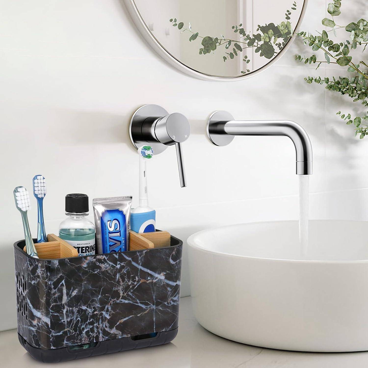 Modernes Badezimmerbecken mit wandmontiertem Wasserhahn und rundem Aufsatzwaschbecken, daneben ein Arbeitsflächenorganizer mit Zahnbürsten und Toilettenartikeln neben einem Spiegel und Grünpflanzen.