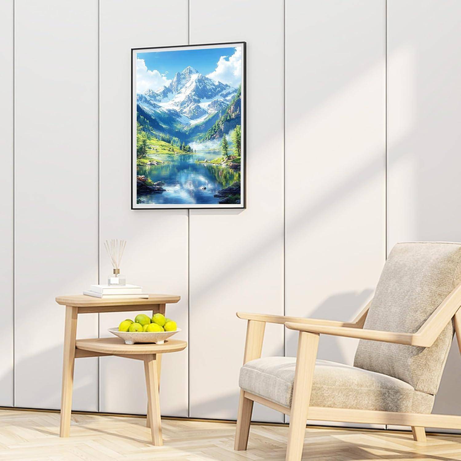 Moderne Lounge-Ecke mit einem beige Sessel, kleinem Beistelltisch mit Äpfeln und gerahmter Bergseenlandschaft an einer hellen Wand.