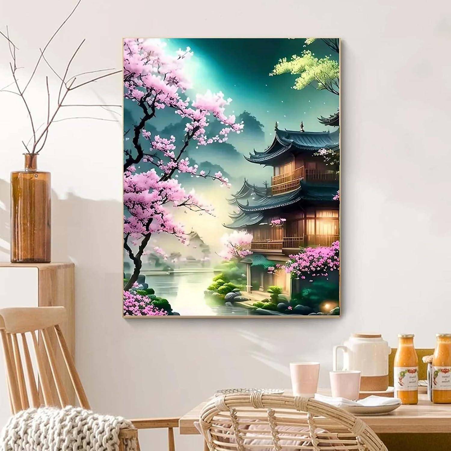 Gerahmtes Gemälde eines ruhigen japanischen Tempels an einem Fluss, mit rosa Kirschblüten und leuchtend illuminierten Laternengebäuden, ausgestellt an einer Esszimmerwand.