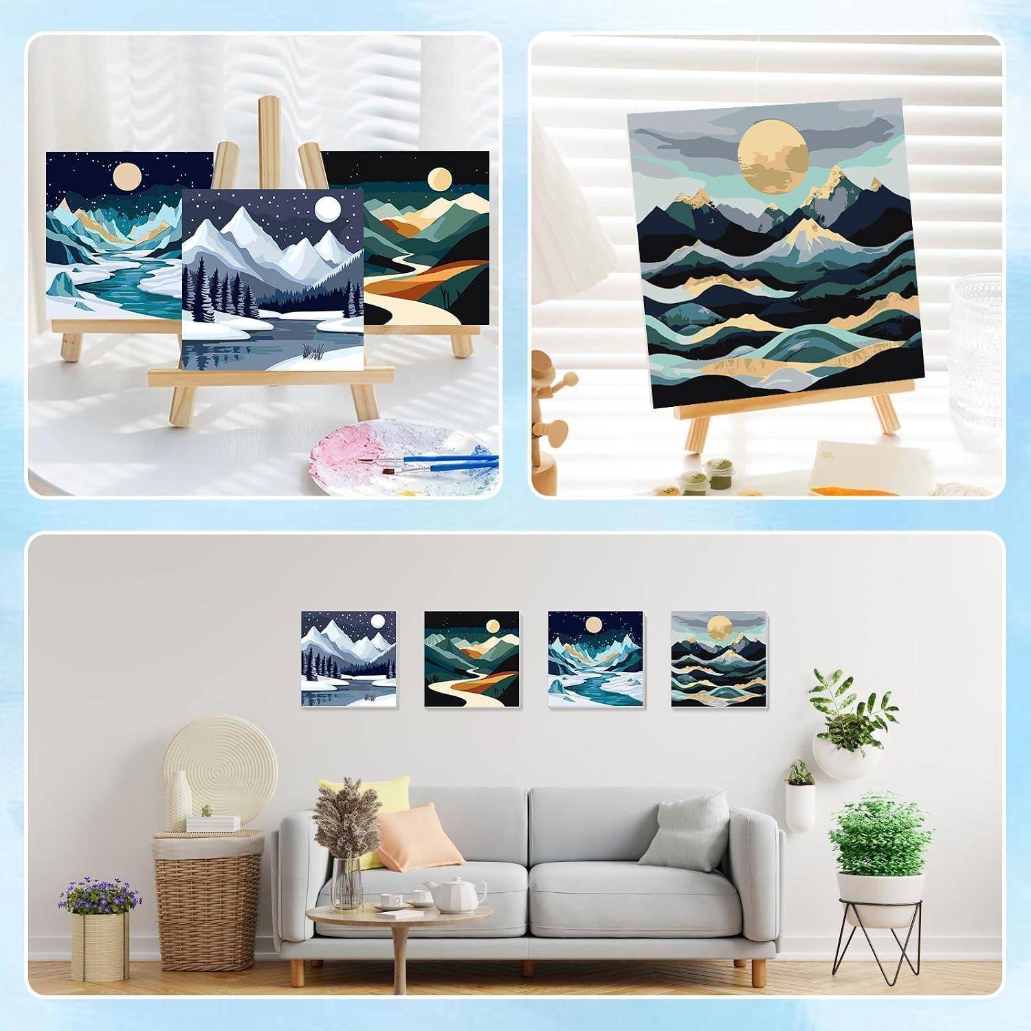 Gerahmte Berglandschaftsdrucke auf Staffeleien und eine Wandgalerie über einem Sofa in einem hellen Wohnzimmer.