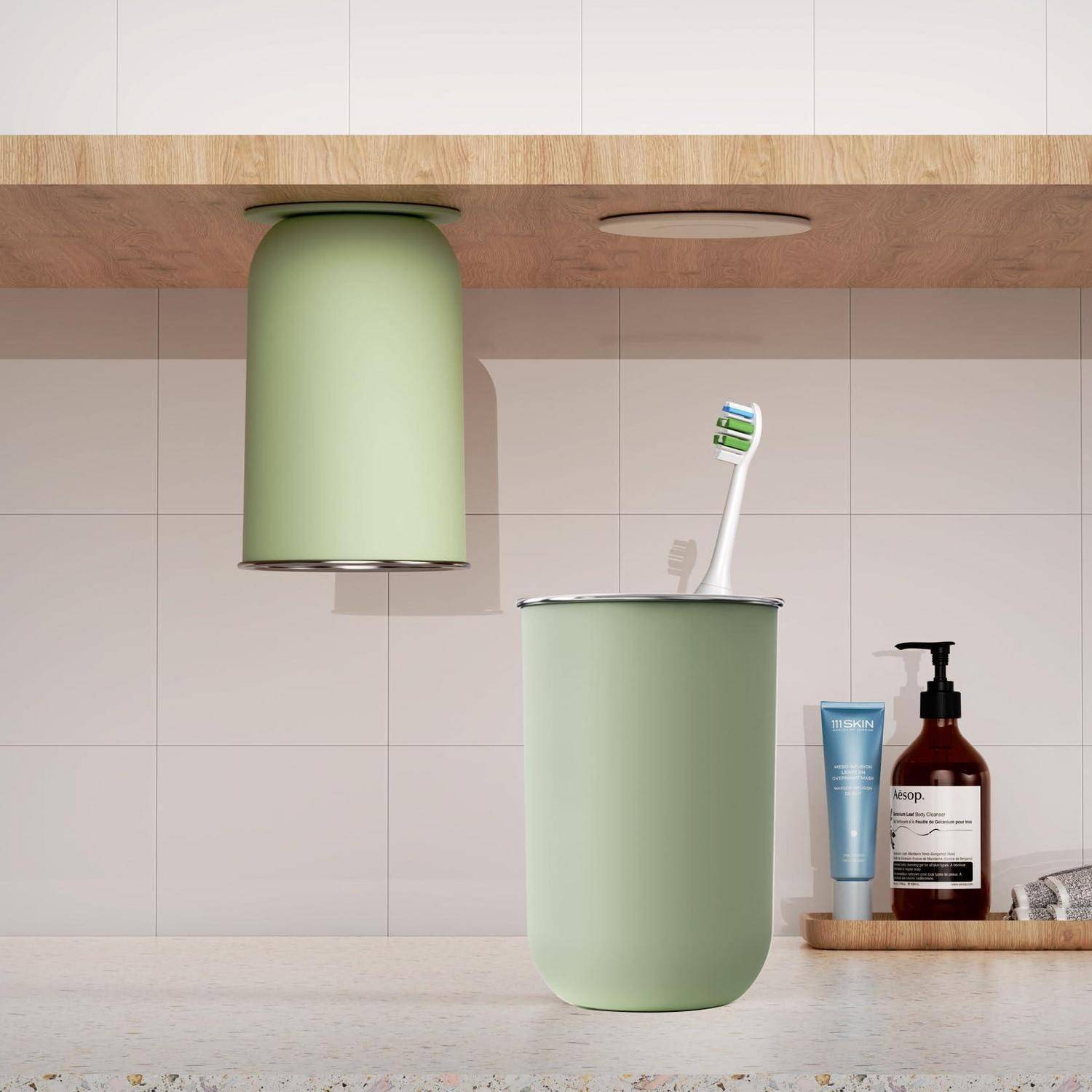 Badezimmerwaschbecken mit einem mintgrünen Becher und einer Zahnbürstenhalterung unter einem Holzregal, mit einer Zahnpastatube und einem Seifenspender auf der Arbeitsplatte.