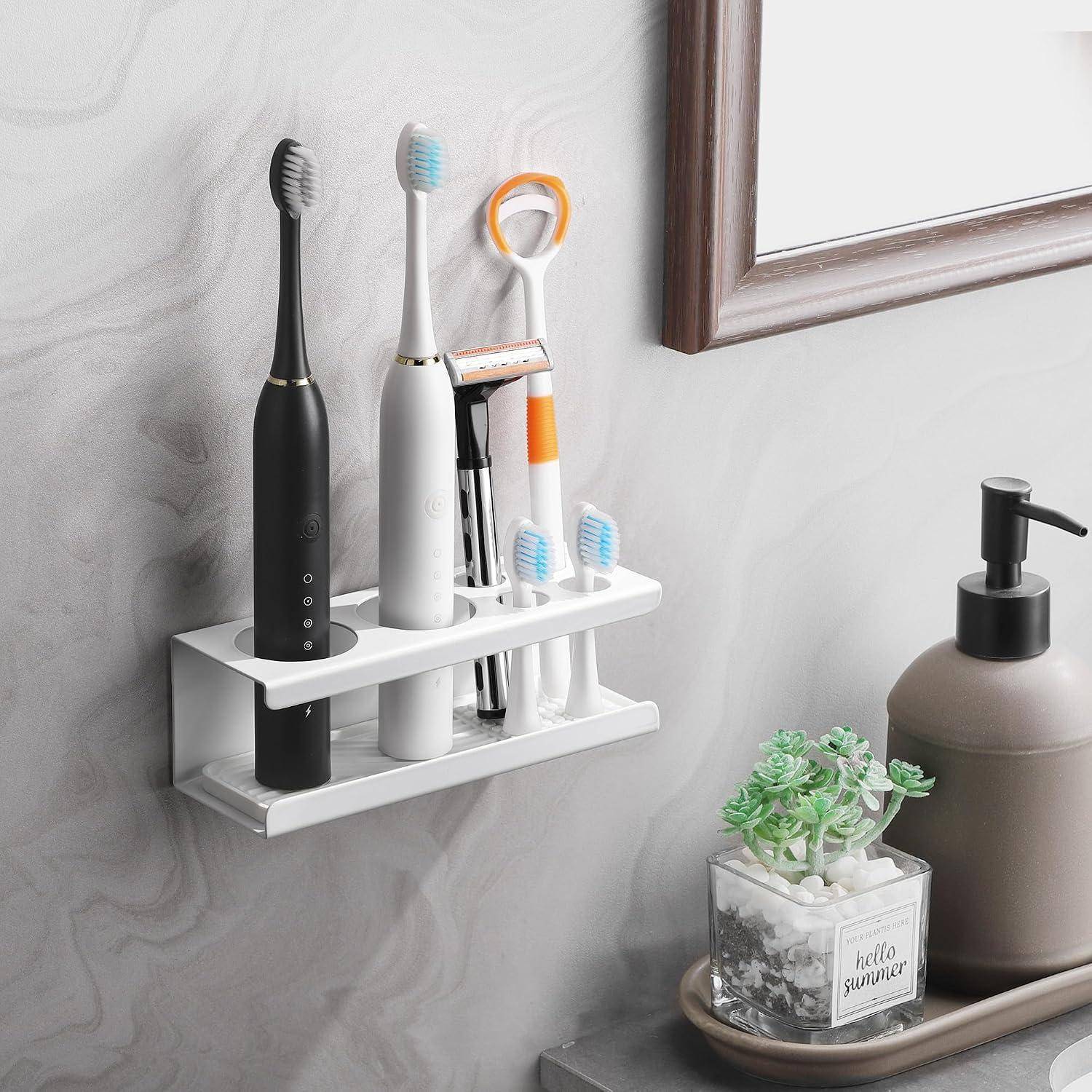 Wandmontierter Badorganizer mit zwei elektrischen Zahnbürsten, Rasierapparaten und einer Tasse neben einem Seifenspender und einer kleinen Sukkulente auf einem Tablett.