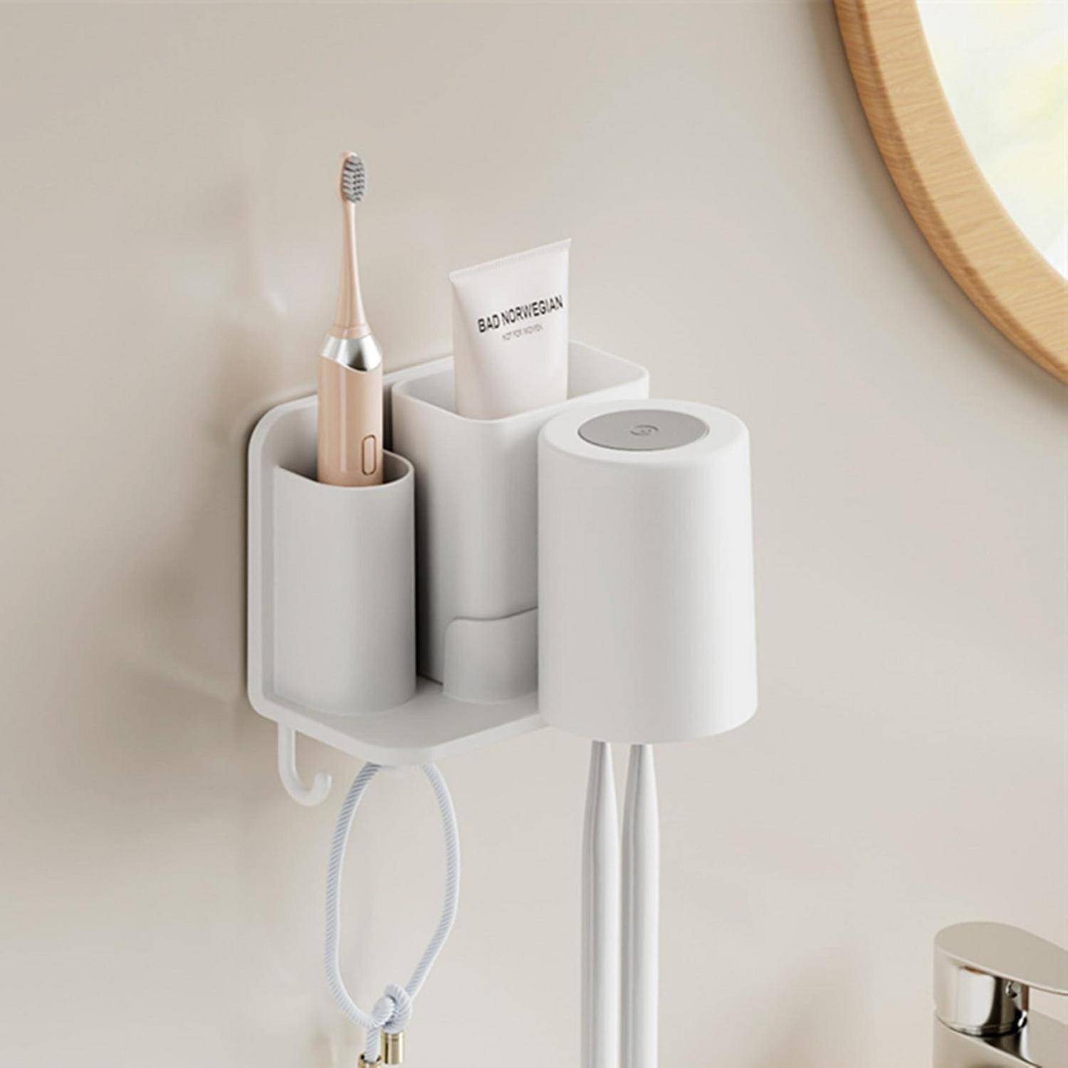 Wandmontierter Badezimmerorganizer mit einer elektrischen Zahnbürste, Zahnpasta und einem Haartrockner mit ordentlich verstautem Kabel.