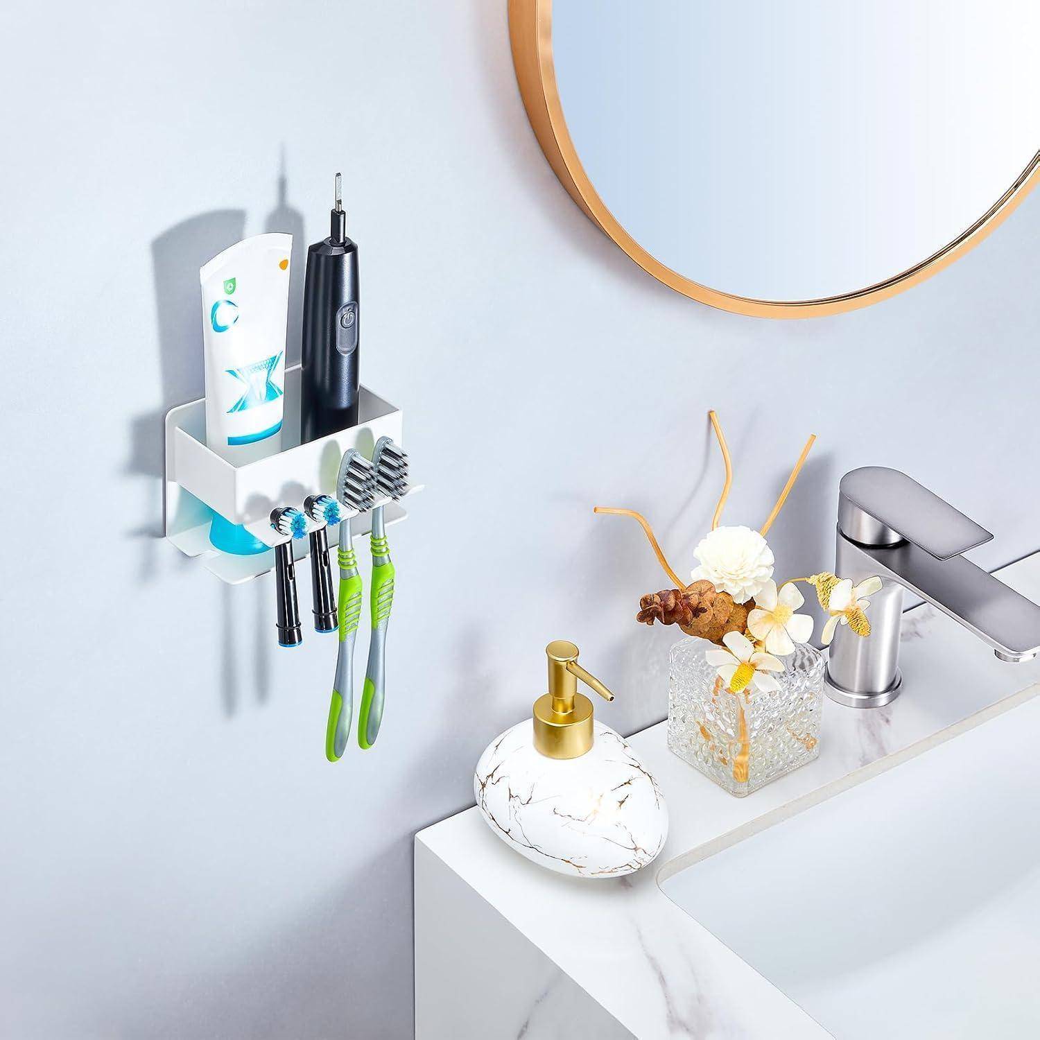 Badezimmerwaschtisch und wandmontierter Behälter mit Zahnpasta, elektrischer Zahnbürste und Bürsten neben einem modernen Wasserhahn und Seifenspender.