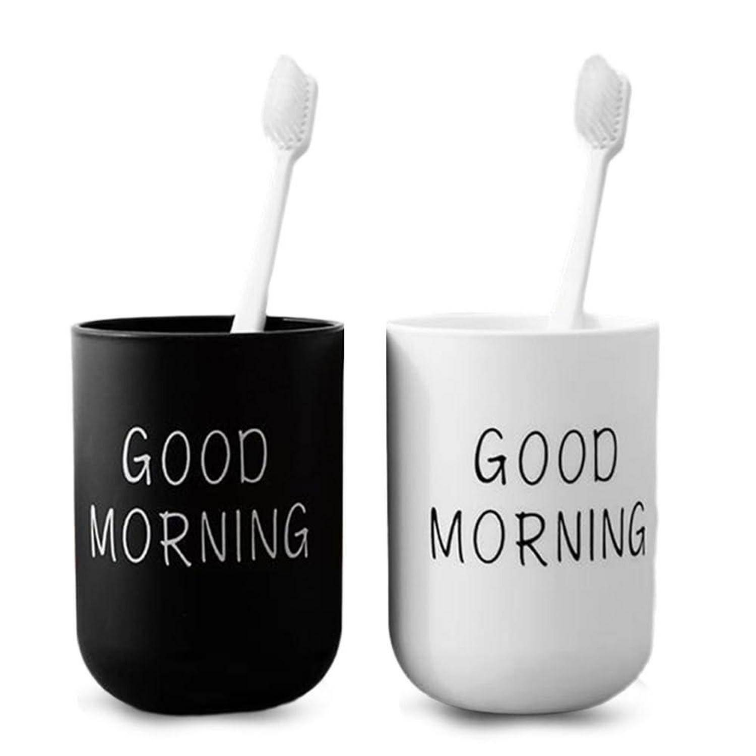 Zwei Zahnbürsten stehen in passenden Bechern, einer schwarzen und einer weißen, beide mit der Aufschrift „GUTEN MORGEN