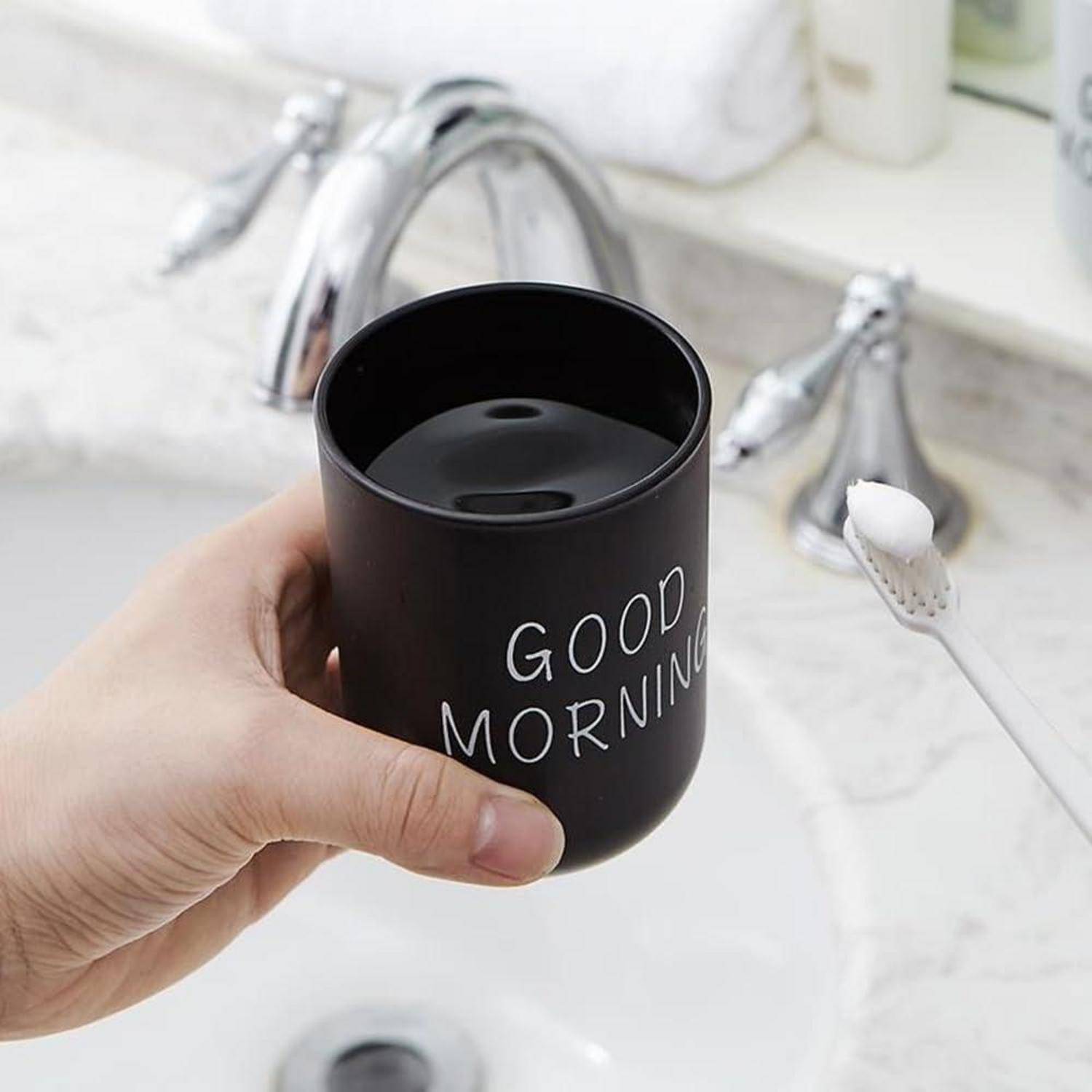 Eine Hand hält eine schwarze Tasse mit der Aufschrift 