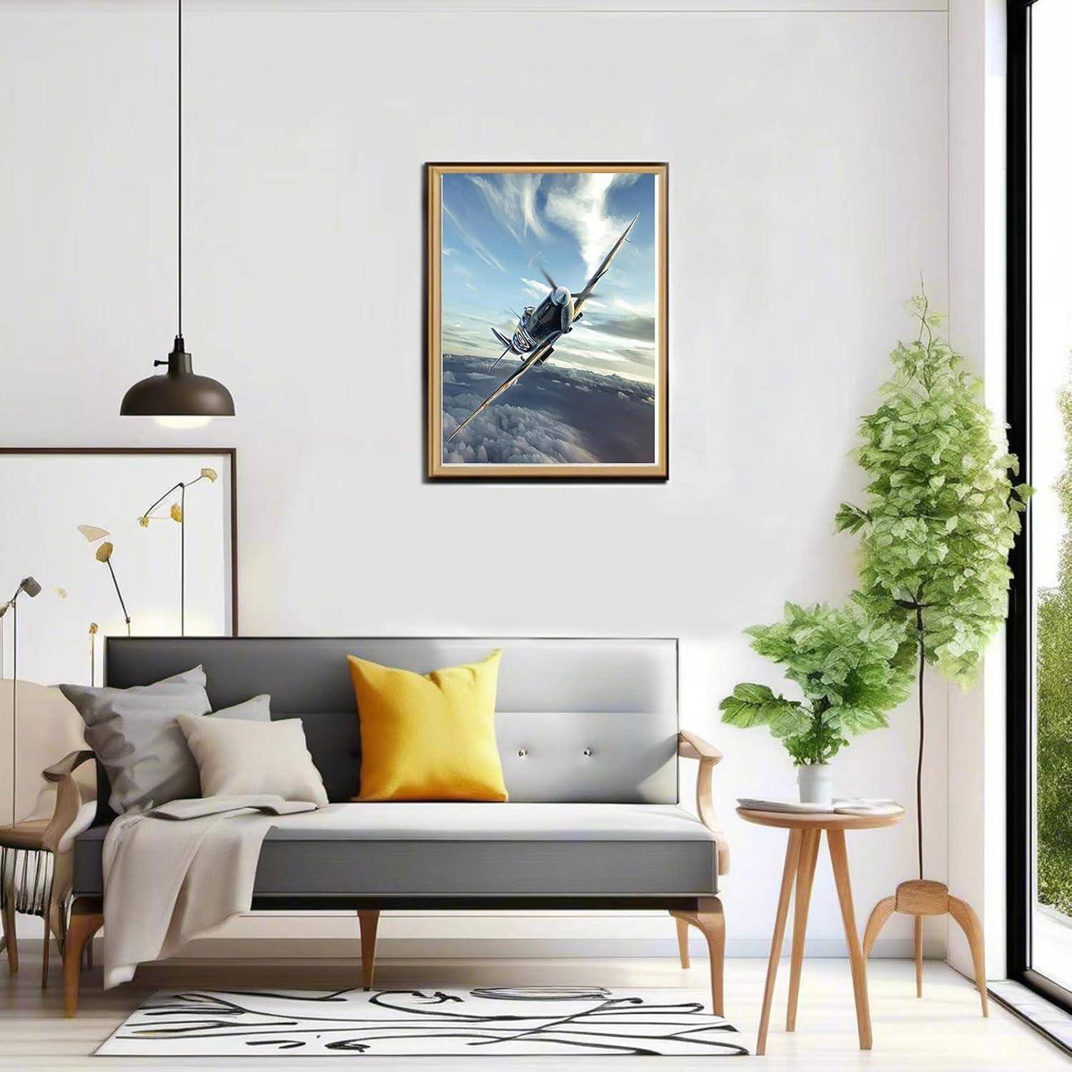 Modernes Wohnzimmer mit grauem Sofa, gelbem Kissen, gerahmtem Flugzeugbild, hängender Lampe, Topfpflanze und raumhohem Fenster.