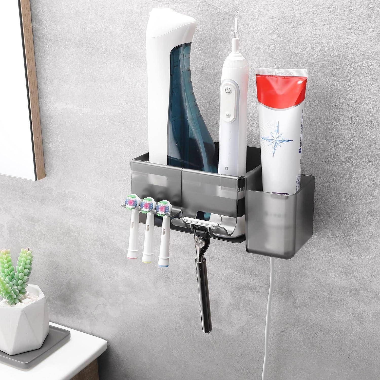An der Wand montierter Badezimmerorganizer, der eine elektrische Zahnbürste, Zahnpasta, Rasierer und andere Toilettenartikel über einem Waschbecken hält.