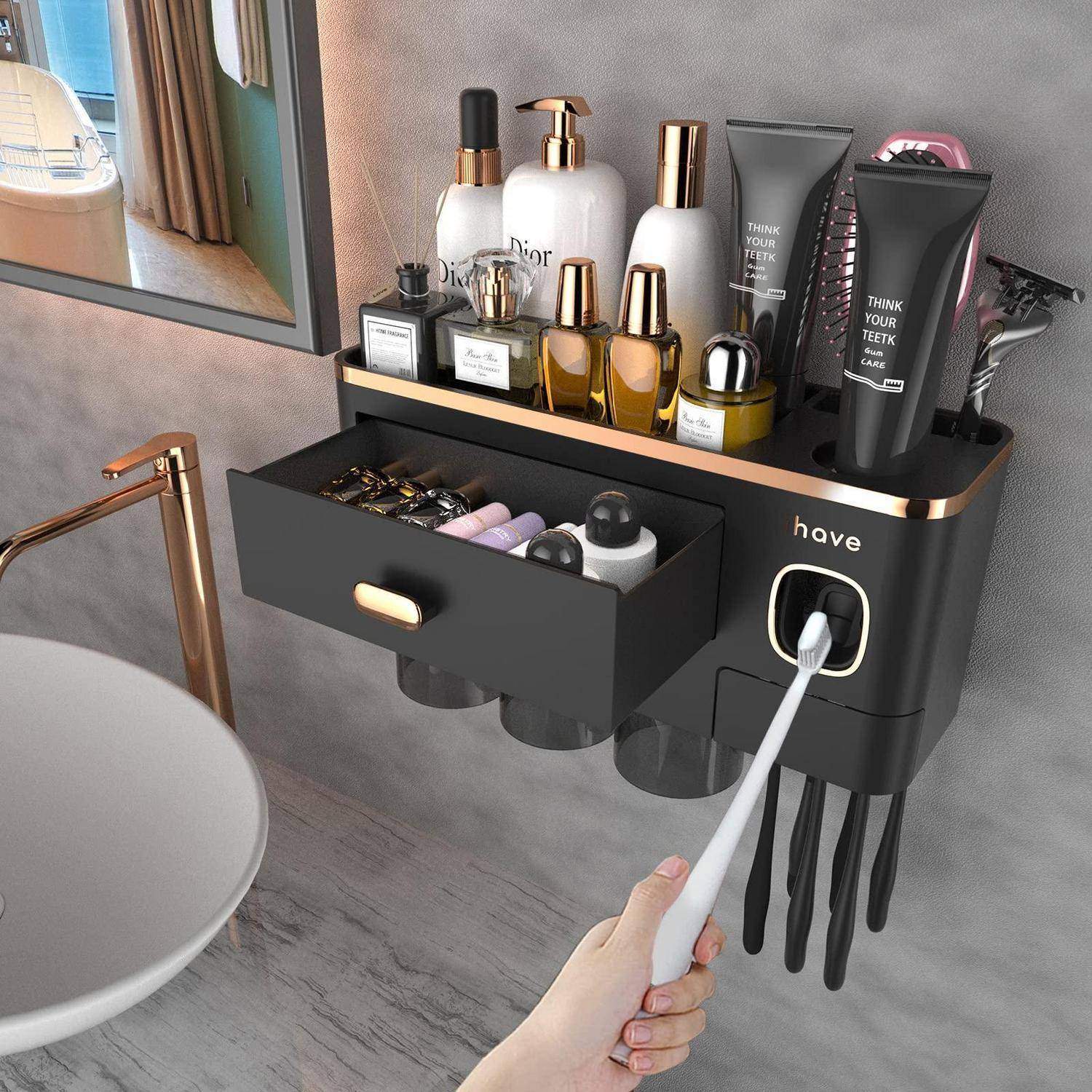 An der Wand montierter schwarz-goldener Badorganizer mit Regal, Schublade, Ladestation für Zahnbürste und Toilettenartikeln; eine Hand hält eine elektrische Zahnbürste neben einem Waschbecken.