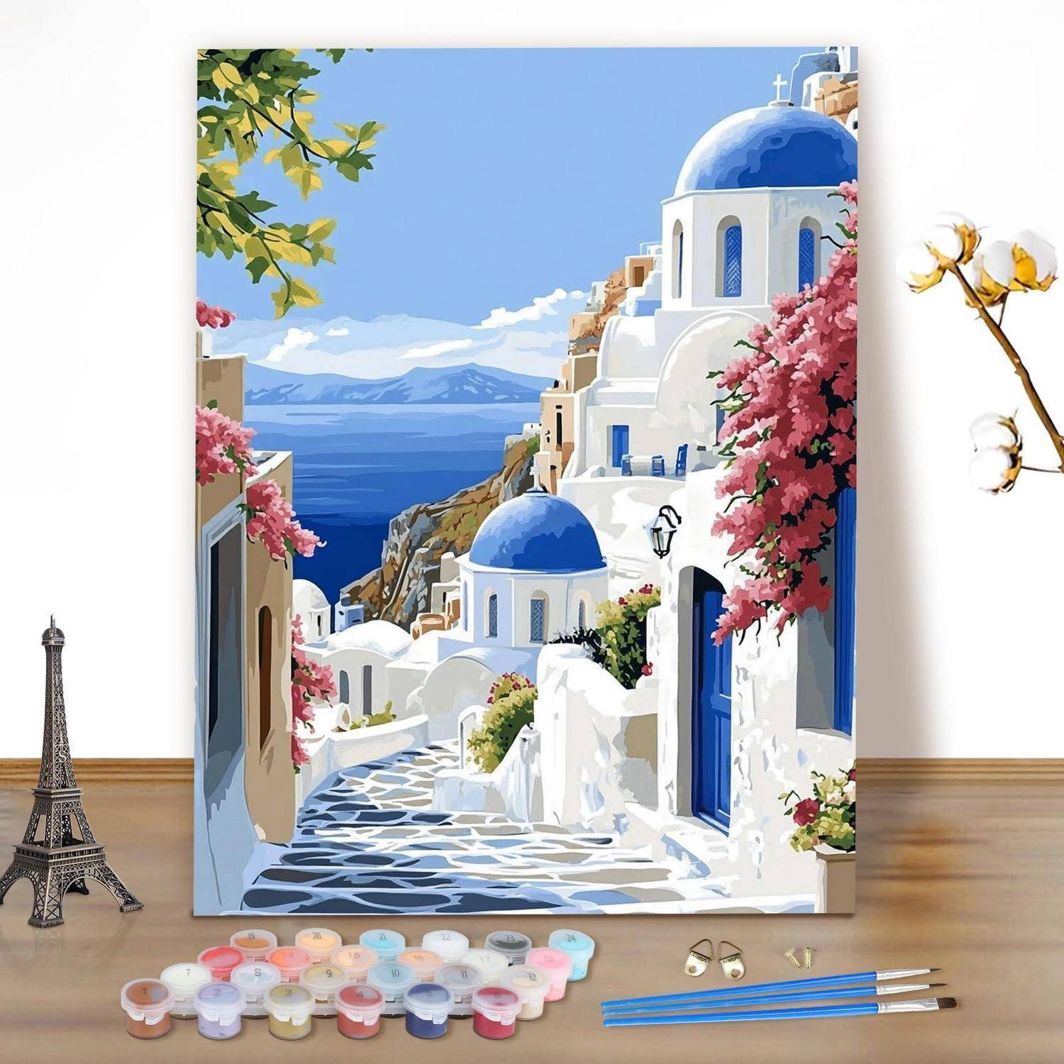 Malvorlagen-Leinwand eines weiß-blauen Küstendorfes mit Kuppeldächern, rosa Blumen und einem Steinweg mit Blick auf das Meer.