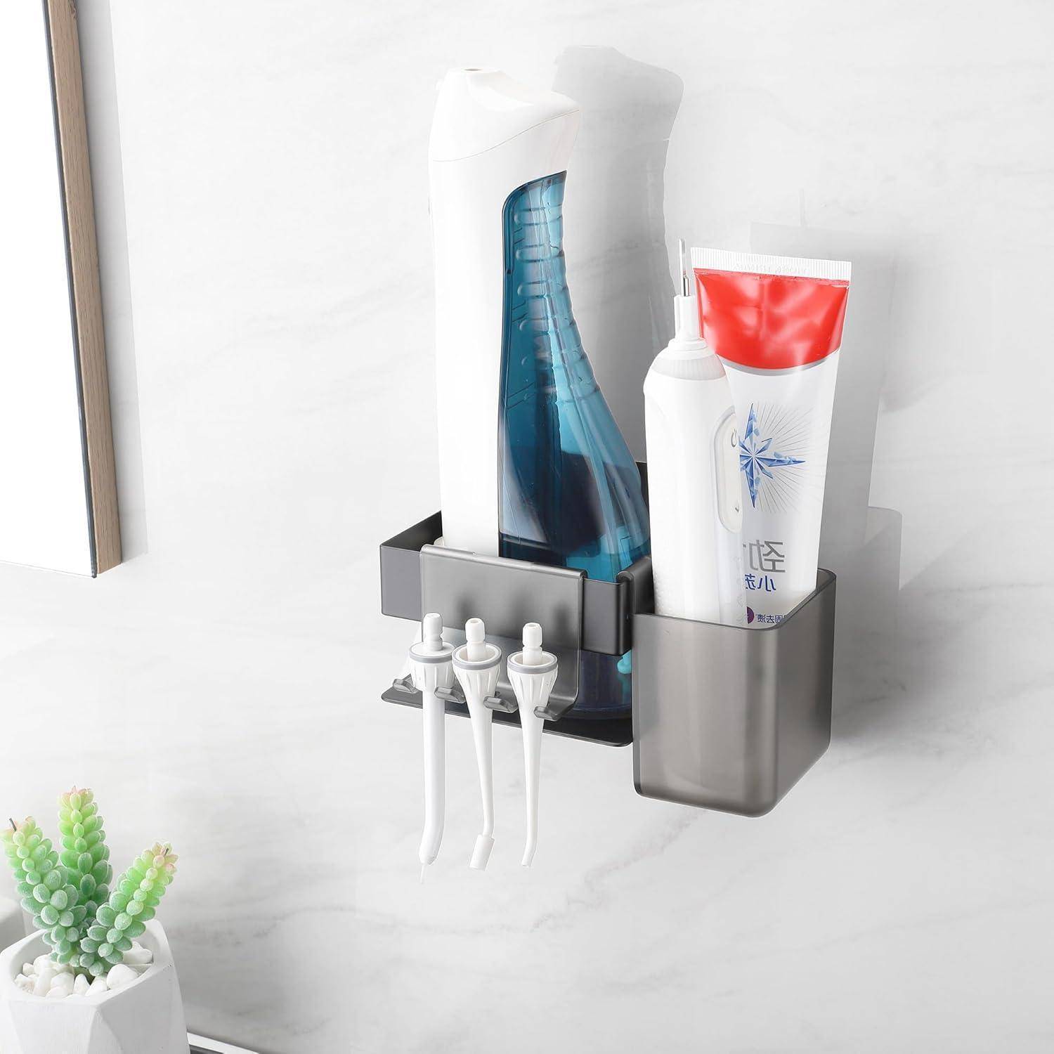 Wandmontierter Badezimmerorganizer mit einer blauen Flasche, einem Zahnbürstenbecher und Zahnpasta, mit Haken darunter zum Aufhängen von Zahnbürsten.