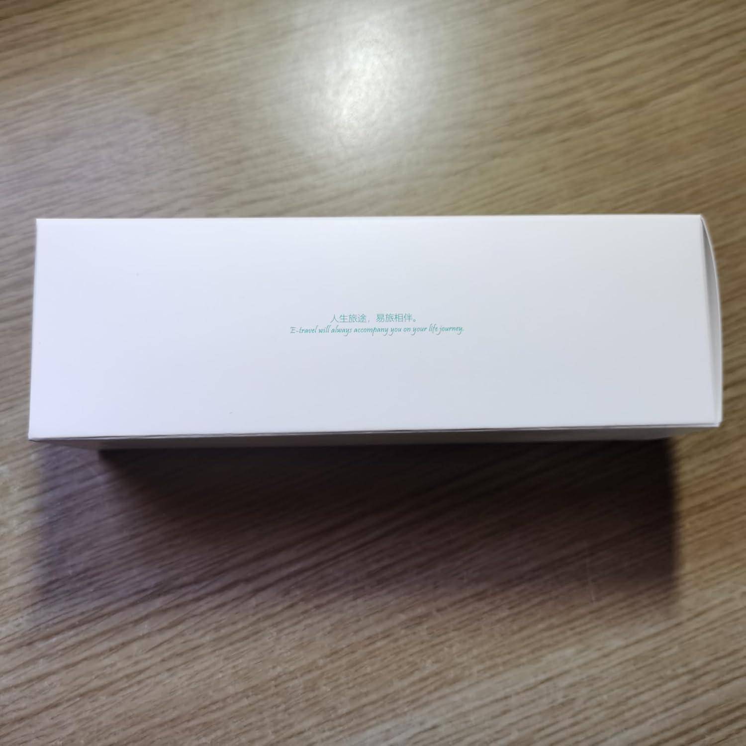 Weiße rechteckige Produktbox auf einer Holzoberfläche, mit kleinem zentriertem chinesischen und englischen Text auf dem Deckel.