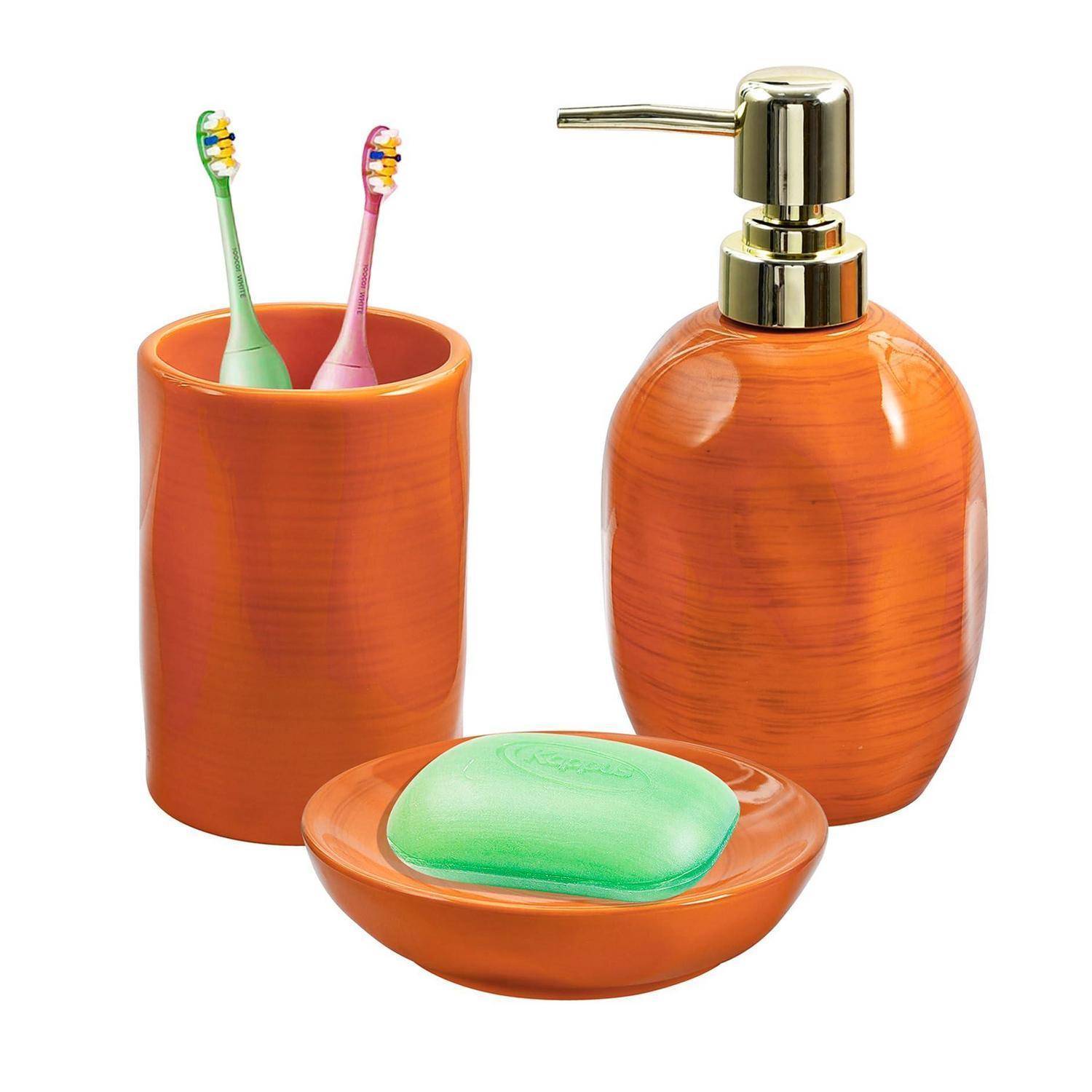 Oranges Badezimmerset mit Zahnbürstenhalter, Seifenspender und Seifenschale mit grüner Seife auf weißem Hintergrund.