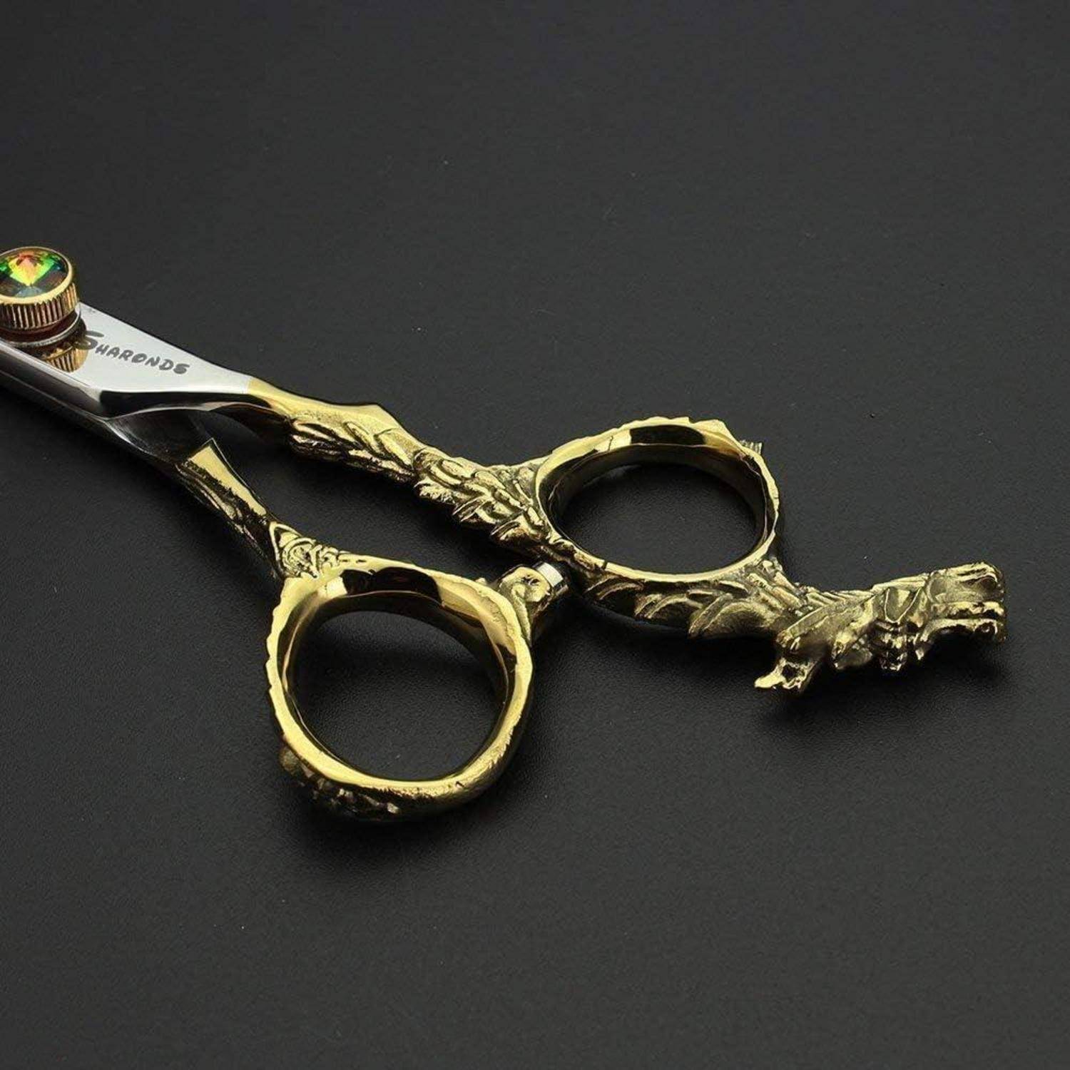 Verzierte Scheren mit goldenem Griff und dekorativen drachenatigen Details, geschlossen auf dunklem Hintergrund liegend.