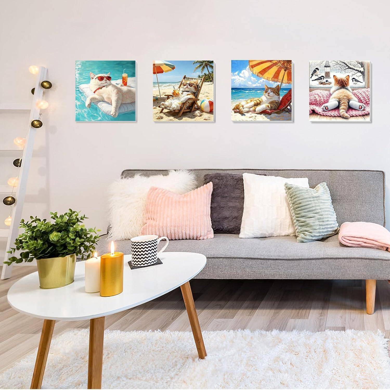 Helles modernes Wohnzimmer mit grauem Sofa, weißem Couchtisch, Pflanze, Kerzen und vier Katzenstranddrucken an der Wand.