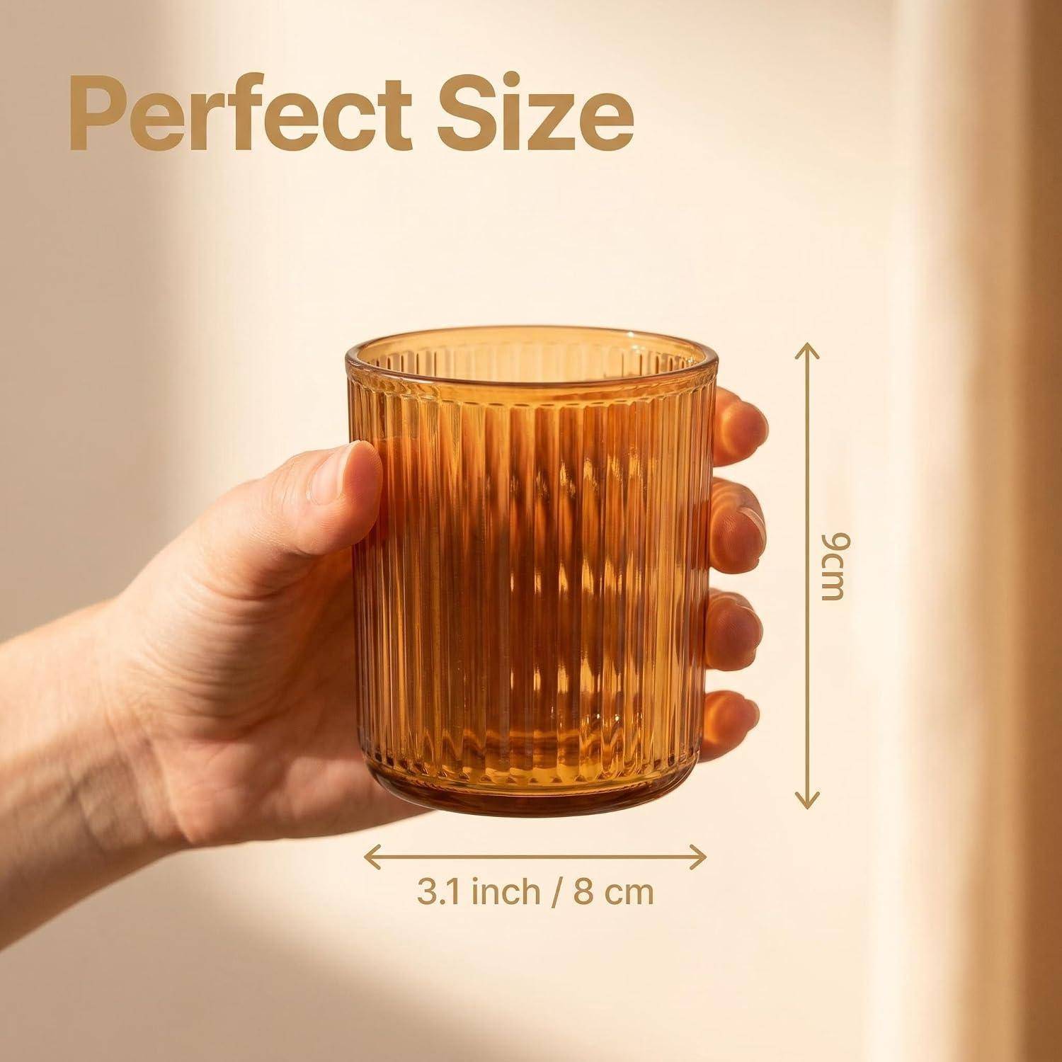 Hand, die ein bernsteinfarbenes geripptes Glas mit der Aufschrift „Perfect Size
