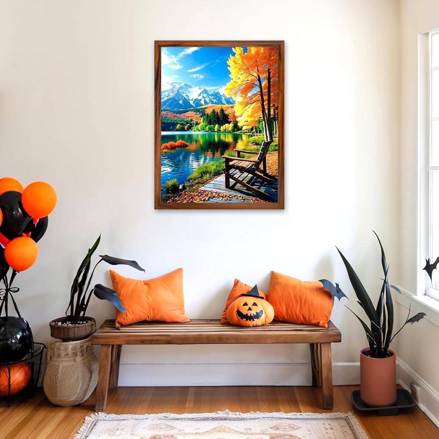 Gemütliche Eingangshalle mit einer Bank, die zu Halloween dekoriert ist, mit orangefarbigen Kissen, Kürbis-Akzenten, Ballons und Topfpflanzen unter einem gerahmten Herbst-Seenlandschaftsbild.