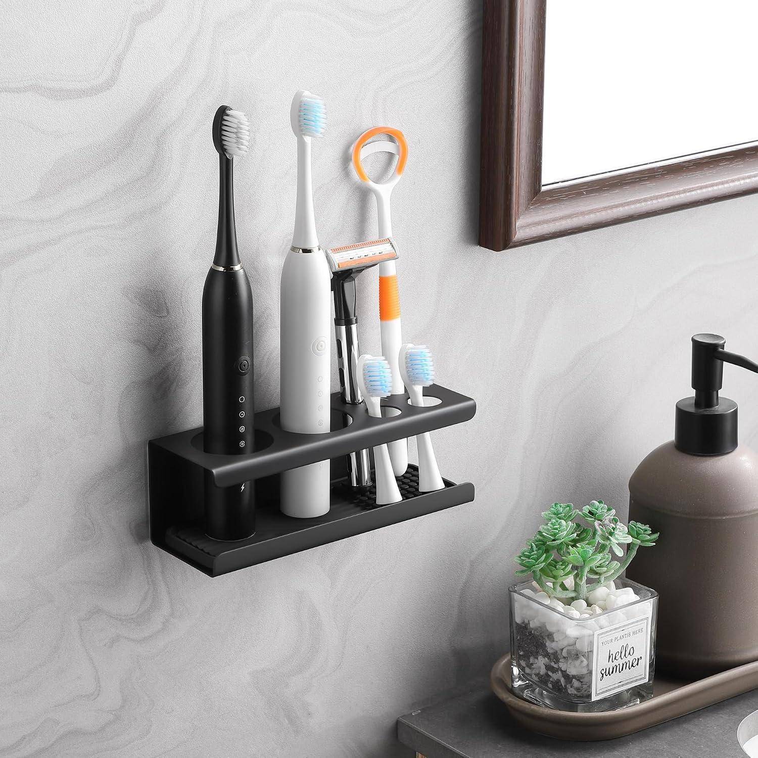 An der Wand montierter Badezimmerorganizer, der zwei elektrische Zahnbürsten, einen Rasierer und andere Zahnpflegeutensilien neben einem Seifenspender und einer kleinen Pflanze hält.