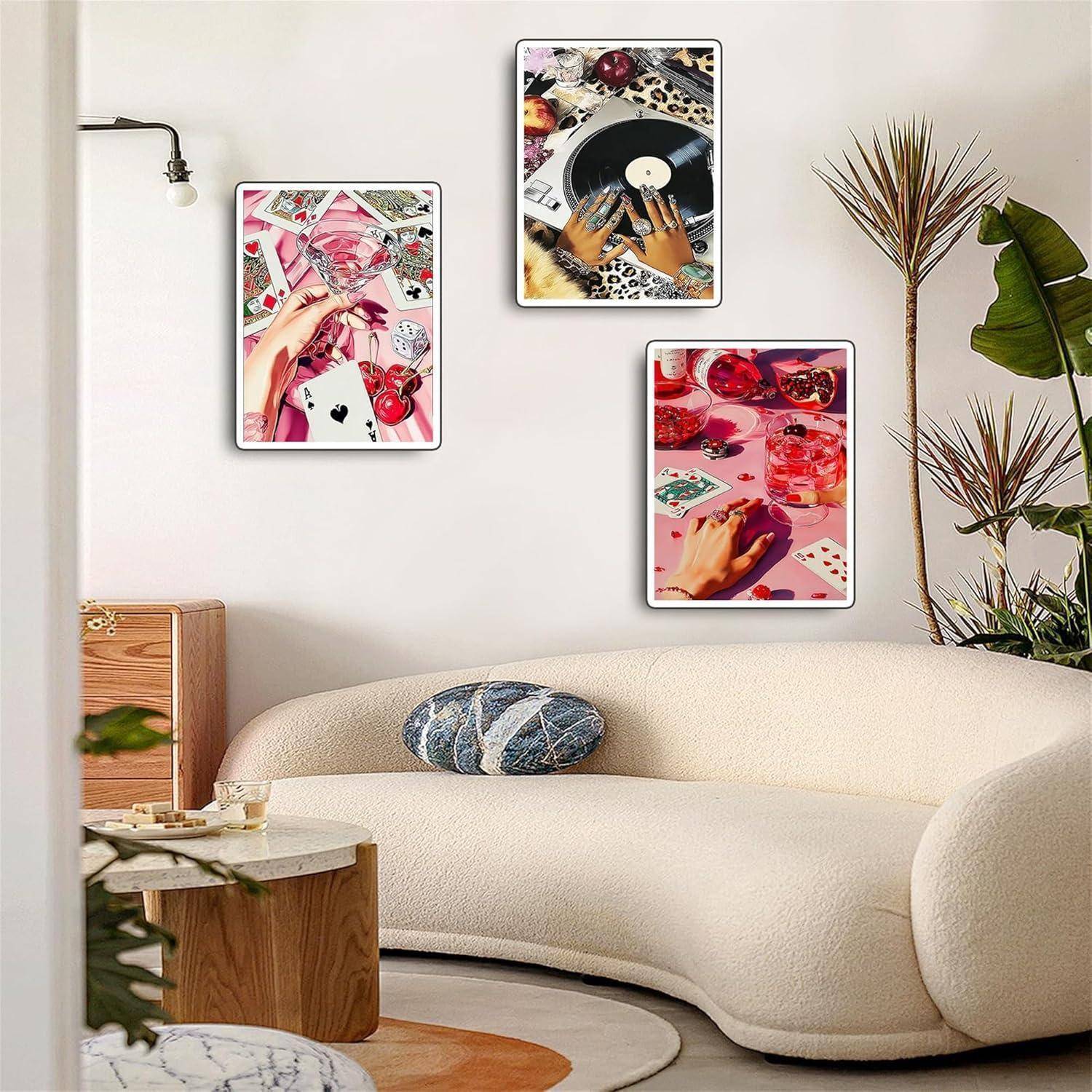 Modernes Wohnzimmer mit cremefarbenem gekrümmtem Sofa und drei gerahmten Kunstdrucken im Retro-Stil an der Wand, plus eine Pflanze und einen runden Tisch.