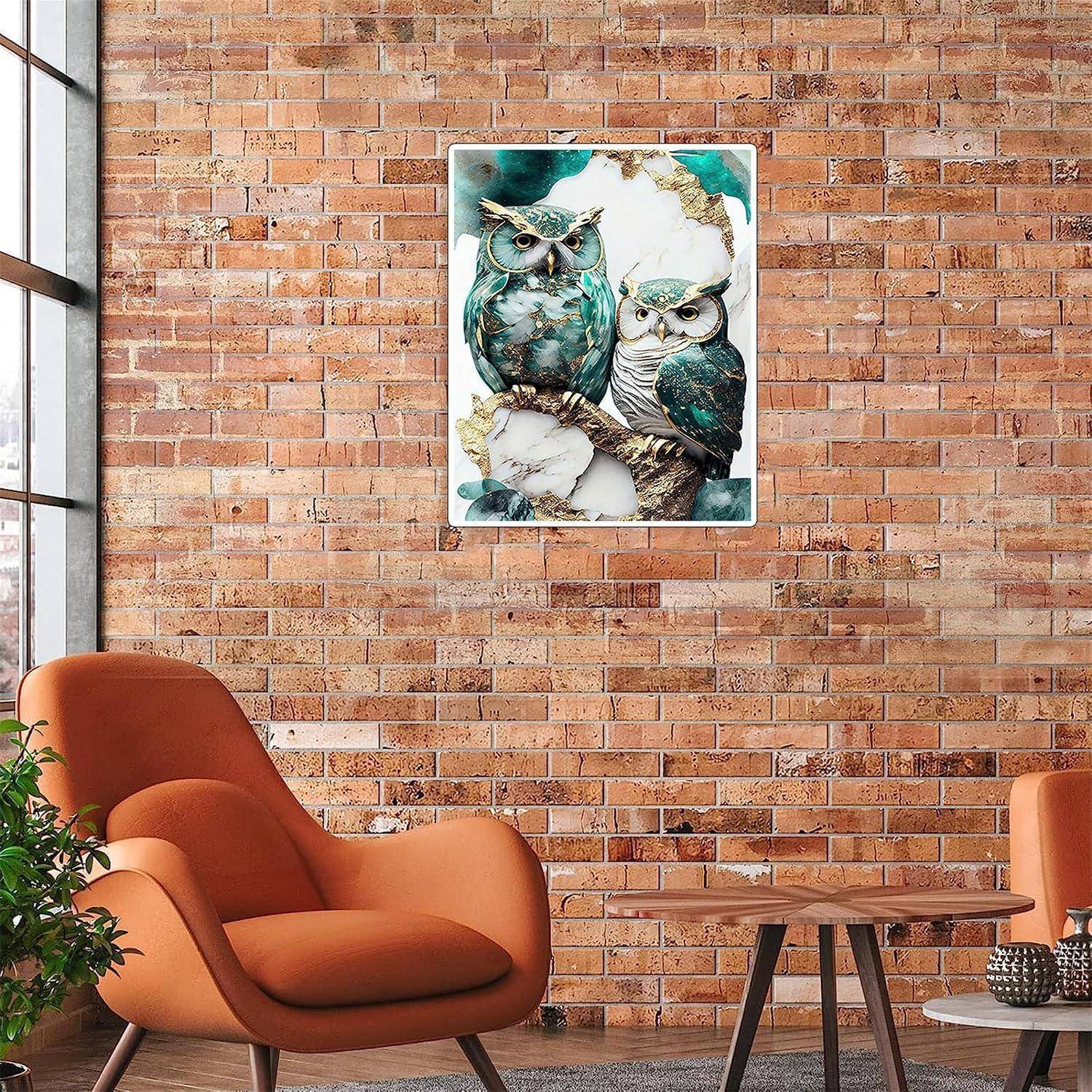 Modernes Wohnzimmer mit orangem Sessel und Beistellstuhl, Holztisch, Ziegelmauer und zentriert über dem Sitzbereich angebrachtem Eulen-Kunstwerk.
