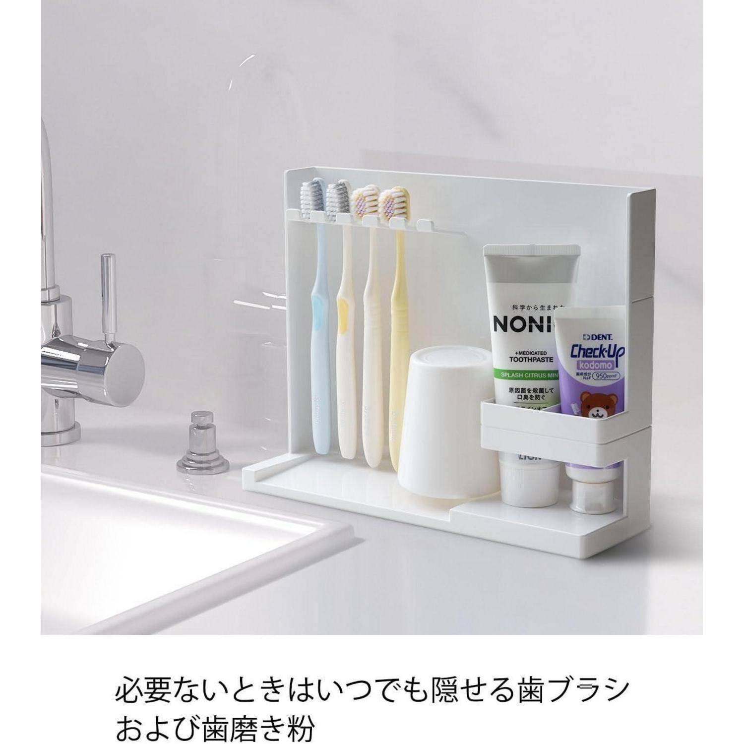 Badezimmer-Waschbeckenschrank mit verstecktem Lagerfach für Zahnbürsten, Zahnpasta und Becher; darunter befindet sich japanischer Text, der einen versteckbaren Zahnbürstenhalter und Zahnpasta-Speicher bewirbt.