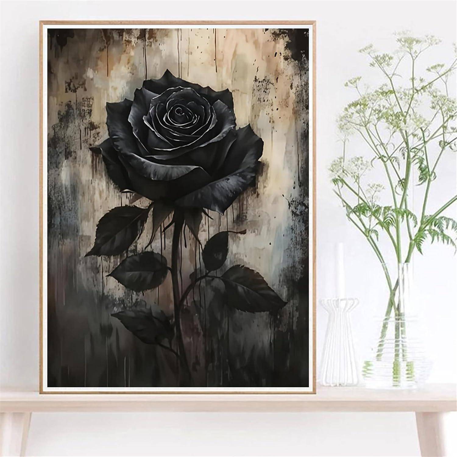 Gerahmtes Kunstwerk einer einzelnen schwarzen Rose auf einem verwitterten Hintergrund, ausgestellt auf einem Regal neben einer Vase mit grünen Blumen.