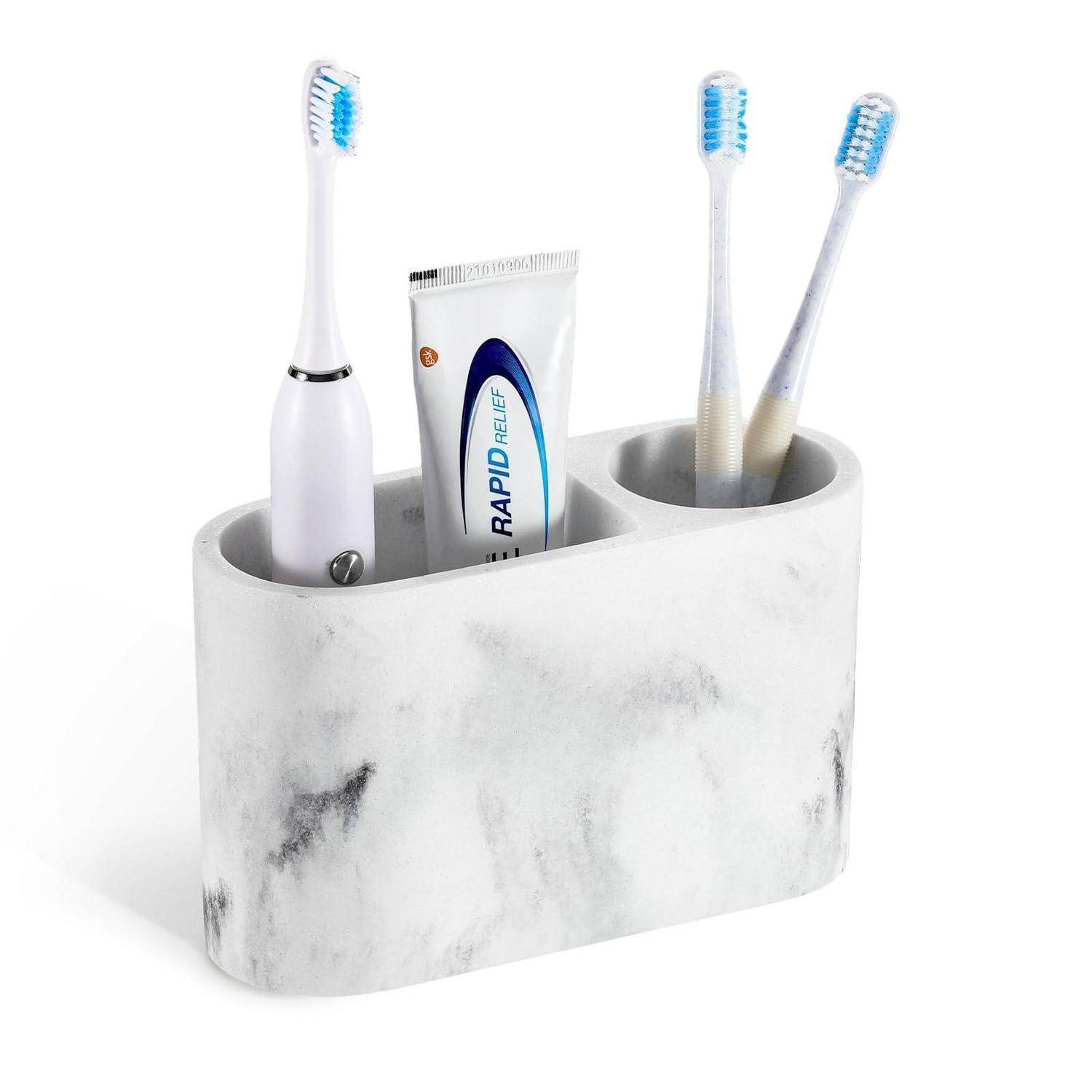 Badezimmer-Caddy mit Marmor-Optik, der drei Zahnbürsten und eine Zahnpastatube hält.