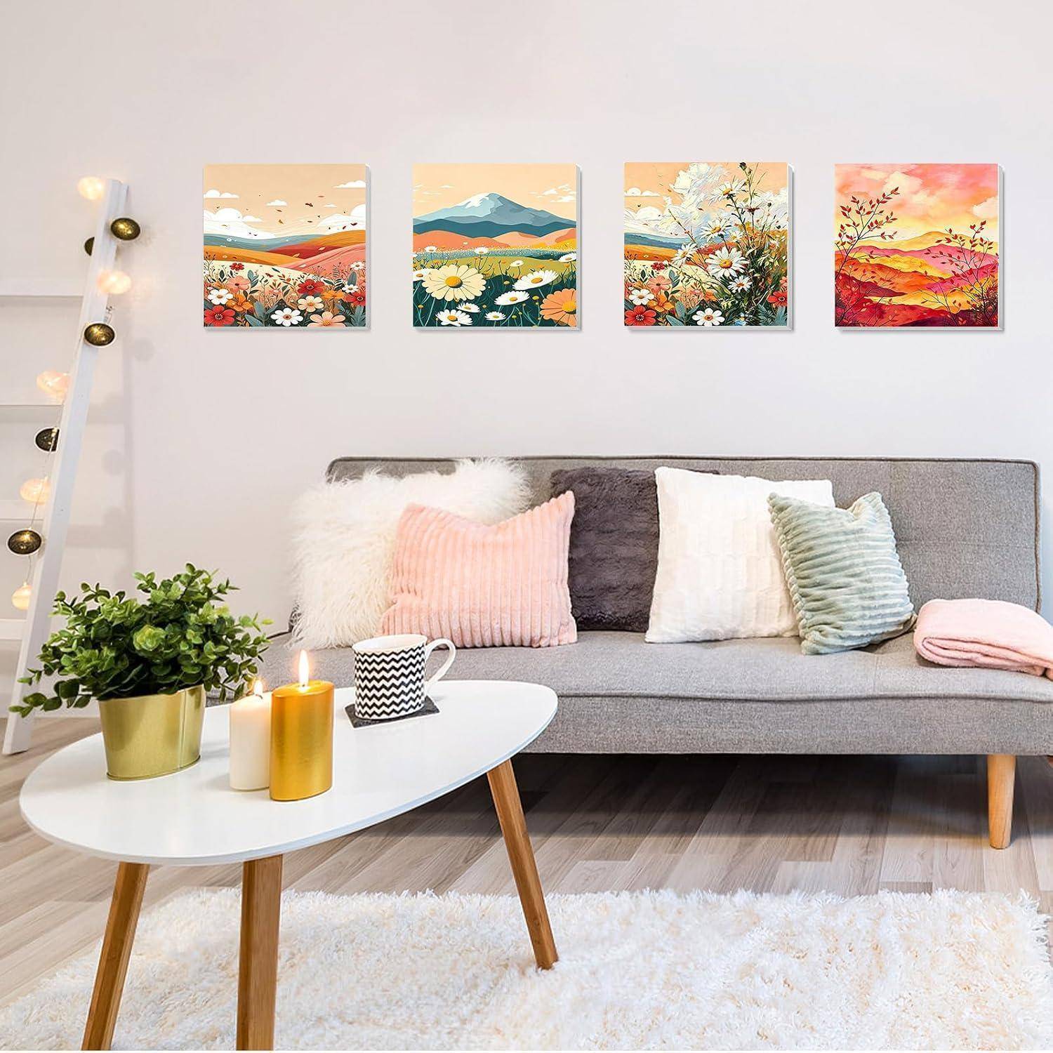 Gemütliches Wohnzimmer mit grauem Sofa, weißem Couchtisch, Kerzen, Pflanze und vier farbenfrohen Landschaftsdrucken an der Wand.