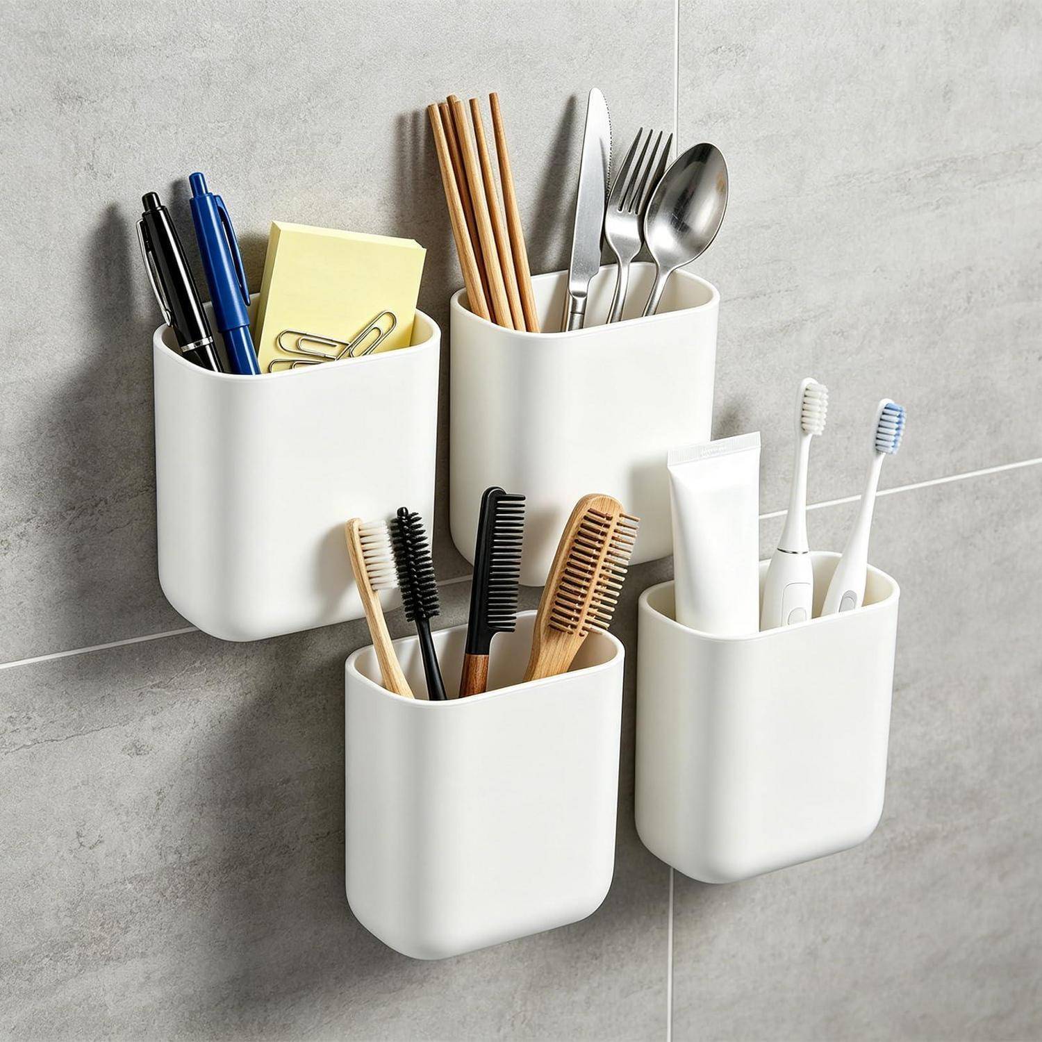 Vier weiße an der Wand befestigte Organizer-Behälter, die Stifte, Utensilien, Makeup-Pinsel und Zahnbürsten auf einer gefliesten Wand halten.