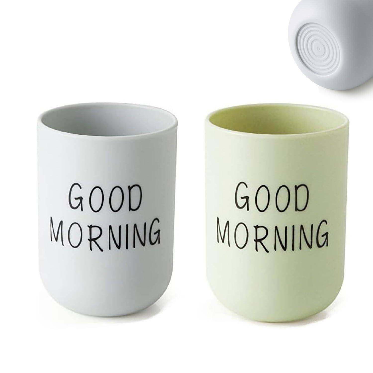 Zwei Keramiktassen, eine hellgrau und eine blassgrün, jeweils mit „GOOD MORNING